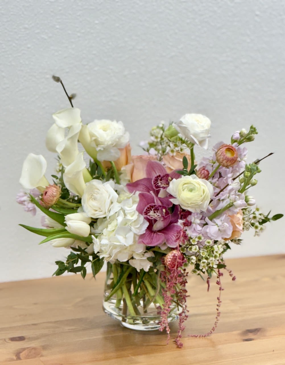 Mixed bouquet in a clear glass vase with white, pink, and peach flowers