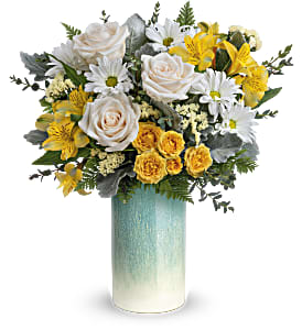 Tall vase of white roses, daisies, and yellow flowers in a blue ombré cylinder