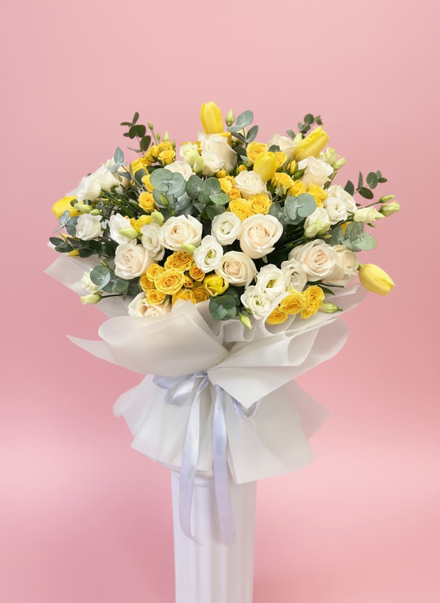 Sunny Love  - Creamy white roses paired with bright yellow tulips create an instantly cheerful spring bouquet ideal for a birthday bouquet, anniversary roses alternative, or a "just because" celebration.   Send this to mark celebrations, welcome a new baby, or brighten someone's day-the colors say optimism and gentle affection so she'll feel noticed and cherished. Order notes: the full, closely packed style arrives ready to display; trim stems and change water every two days to keep blooms looking their best.