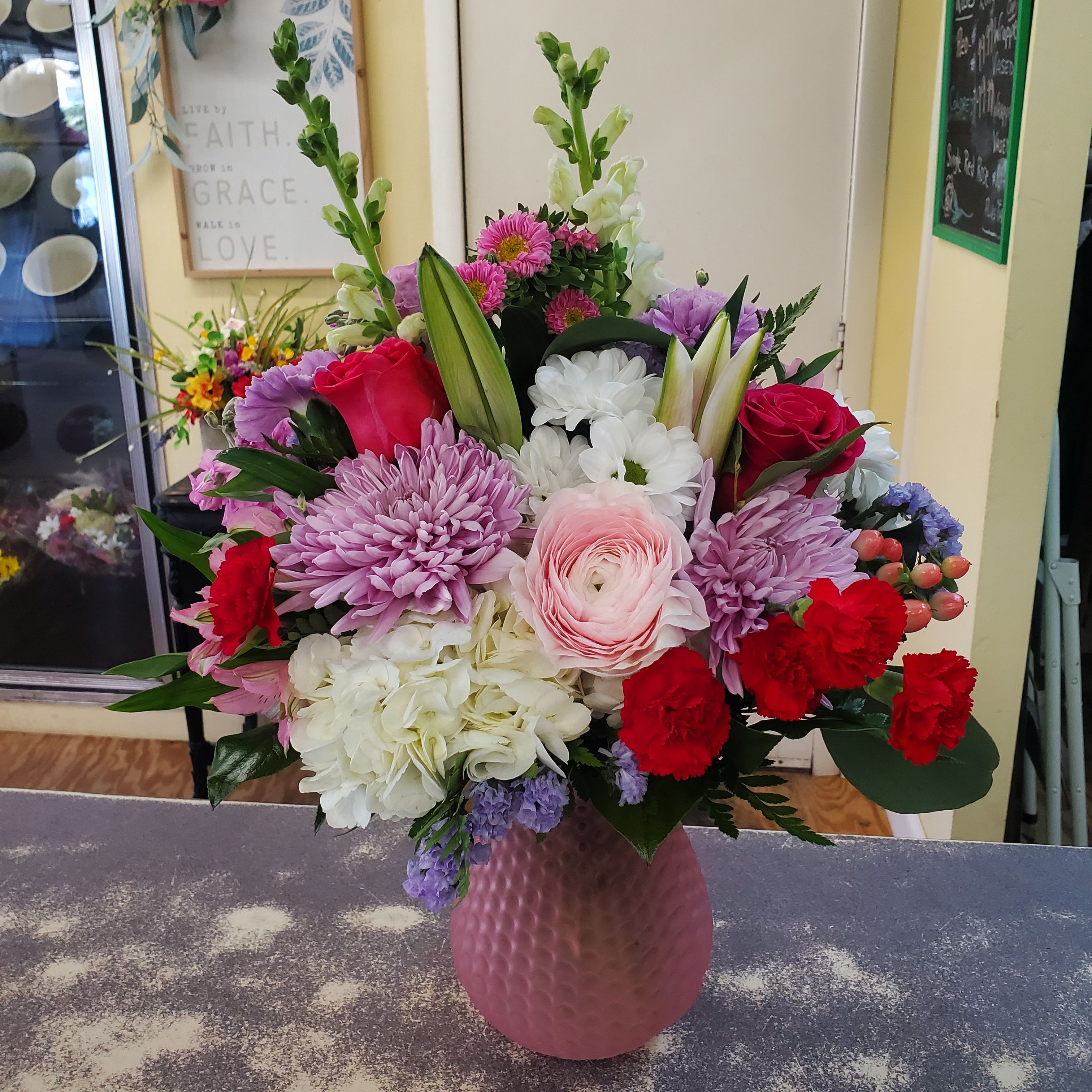 Love for Mom - Compact glass vase filled with assorted flowers and colors to celebrate the one you love.  **PLEASE NOTE..COLORS WILL VARY DEPENDING ON THE AVAILABILITY OF THE DAY**