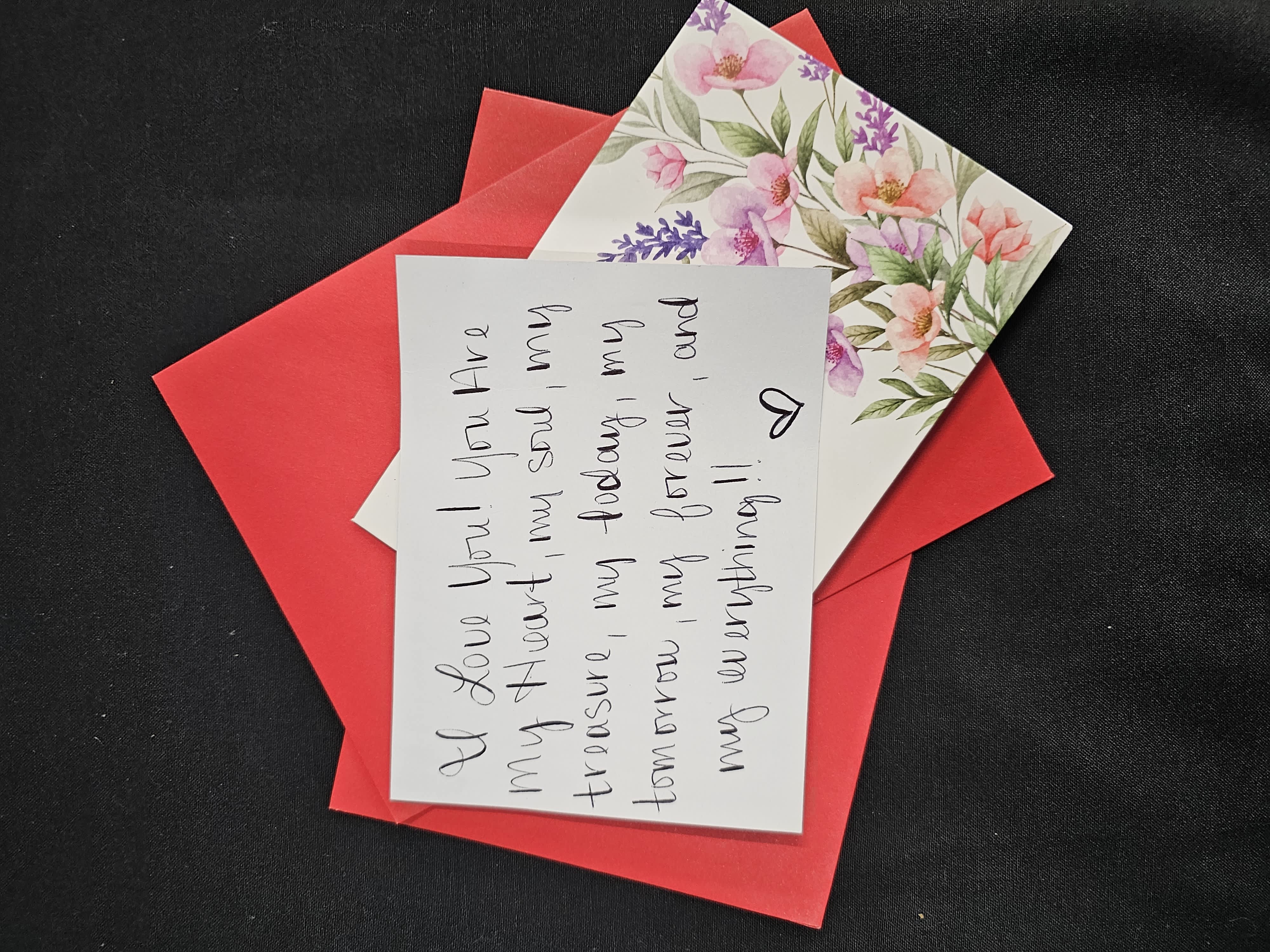 Red envelope with a floral card and handwritten note