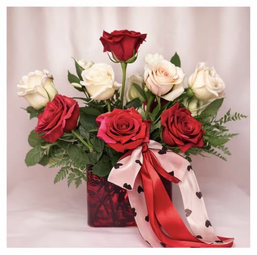 My Valentine - My Valentine is a classic rose arrangement featuring a beautiful blend of rich red and creamy white roses, thoughtfully arranged in a sleek red glass vase and finished with a coordinating ribbon accent. Elegant and timeless, this design captures the essence of romance. Perfect for anniversaries, Valentine’s Day, or heartfelt surprises.