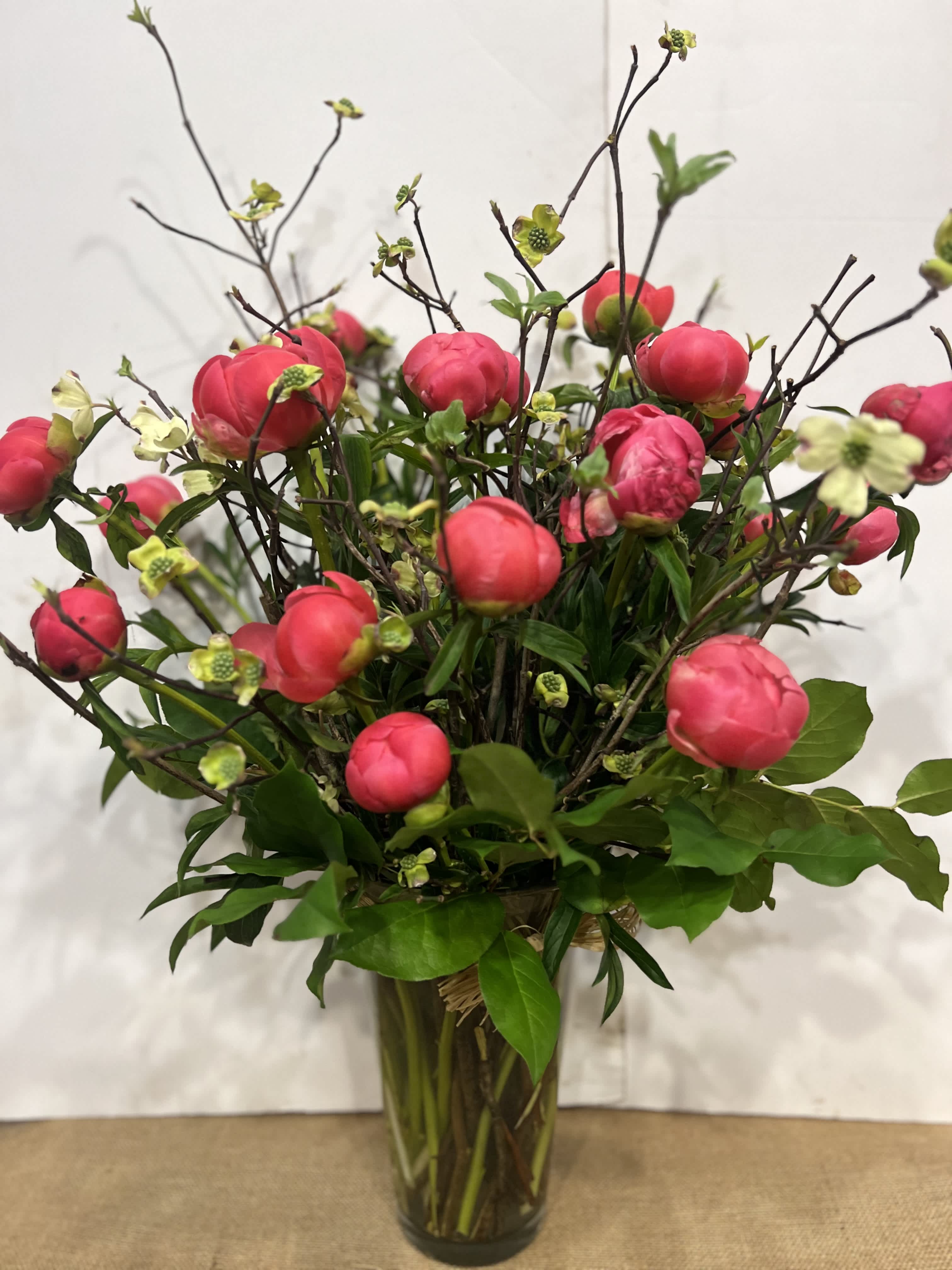 The Coral charm - Medium high floral arrangement compose of an assortment of Coral charm peonies surrounded by seasonal branches. 
