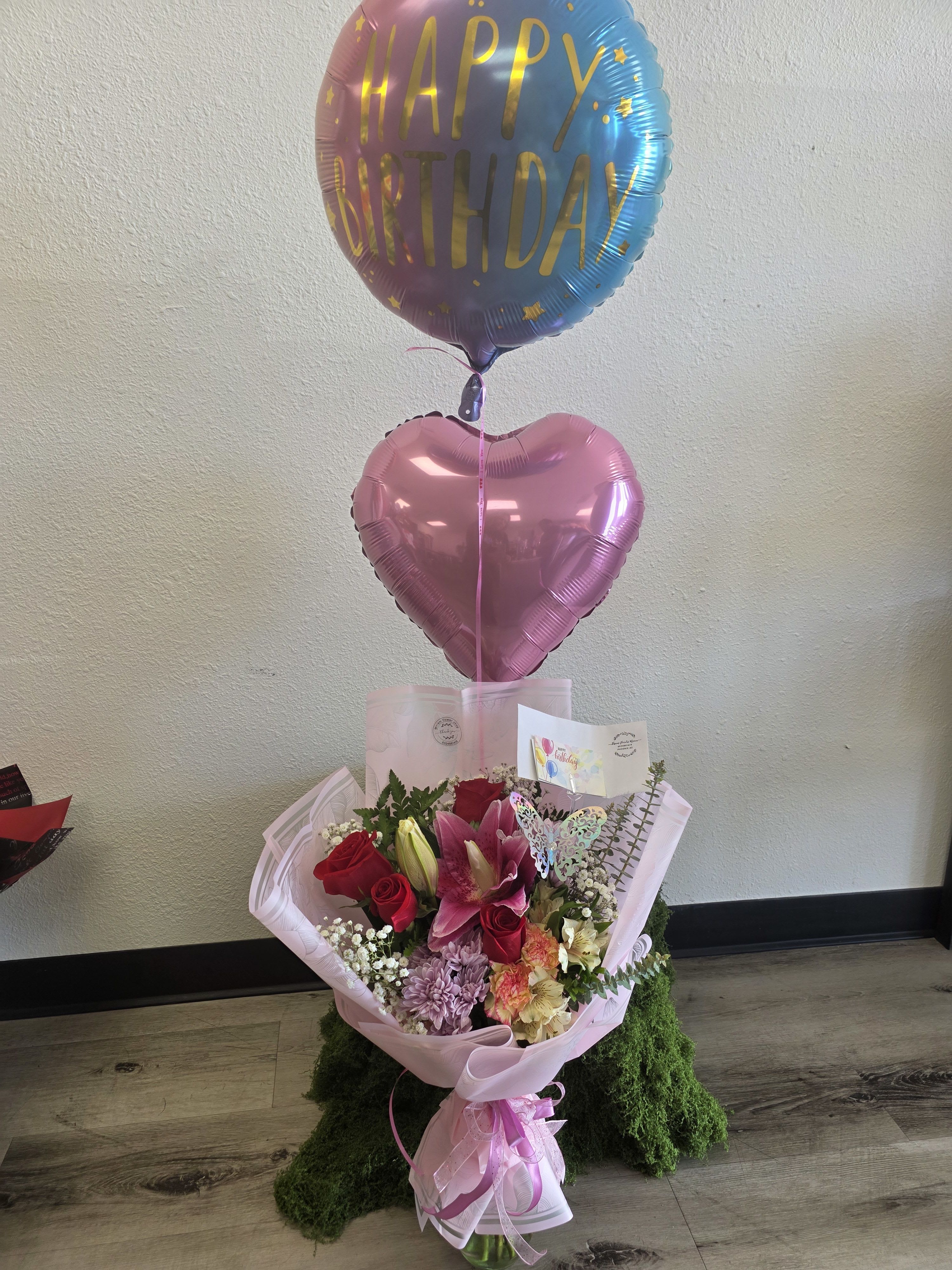 Bouquet of pink and red flowers with birthday balloons