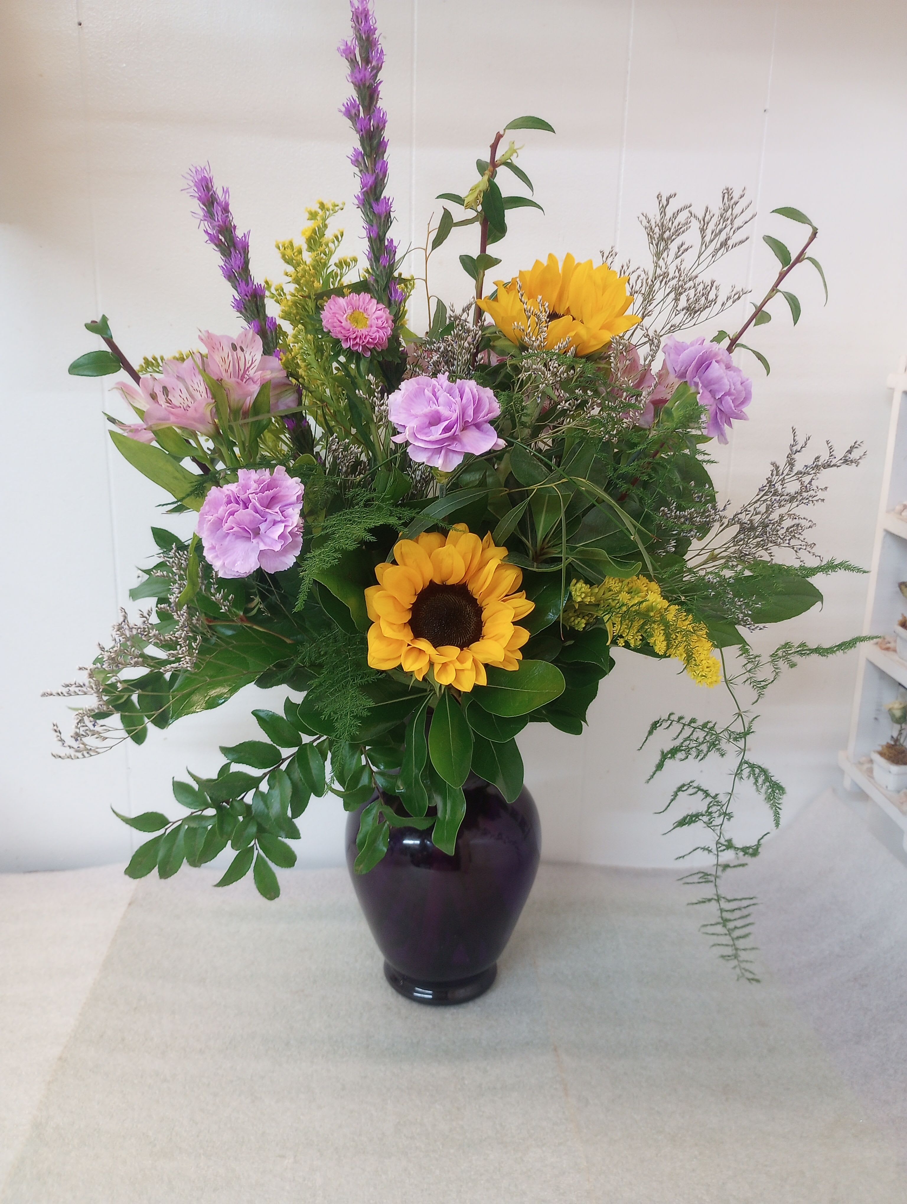 Time for some purple  - Tall purple spikes and delicate pink daisy-like blooms give soft vertical movement while abundant green foliage creates a full, airy silhouette that feels both spontaneous and thoughtfully arranged - the kind of bouquet that makes the person you're thinking of feel delightfully celebrated.