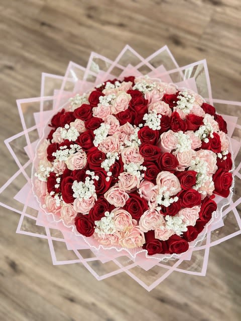 Pink Promise with Baby's Breath - A breathtaking twist on our signature Pink Promise bouquet, this version is delicately accented with soft white baby’s breath to add an ethereal touch. Featuring a luxurious blend of blush pink and rich red roses, this arrangement symbolizes romance, tenderness, and timeless beauty. Wrapped in soft pink geometric paper and tied with elegance, it’s the perfect gift for celebrating love, special milestones, or simply making her day unforgettable.