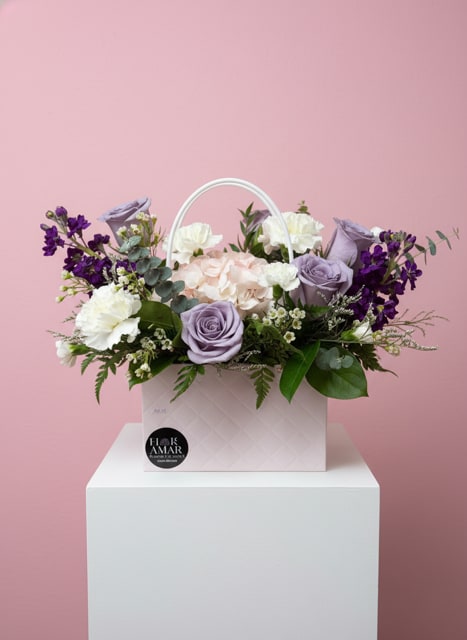 Lavender Whisper Box - A soft and elegant arrangement featuring lavender roses, hydrangeas, and delicate seasonal blooms, beautifully styled in a modern Floramar signature box with handle. Lavender Whisper Box captures serenity, grace, and refined beauty—perfect for expressing admiration, love, and thoughtful sentiments.