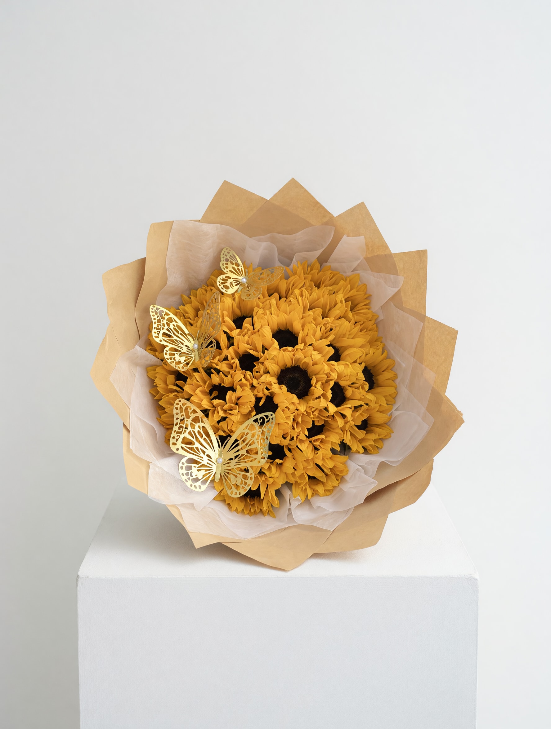 Golden Sunshine Bouquet - A radiant bouquet of vibrant sunflowers, beautifully wrapped in warm neutral tones and accented with delicate decorative butterflies. Golden Sunshine Bouquet is designed to bring happiness, positivity, and light into any space—perfect for celebrating joyful moments and brightening someone’s day.