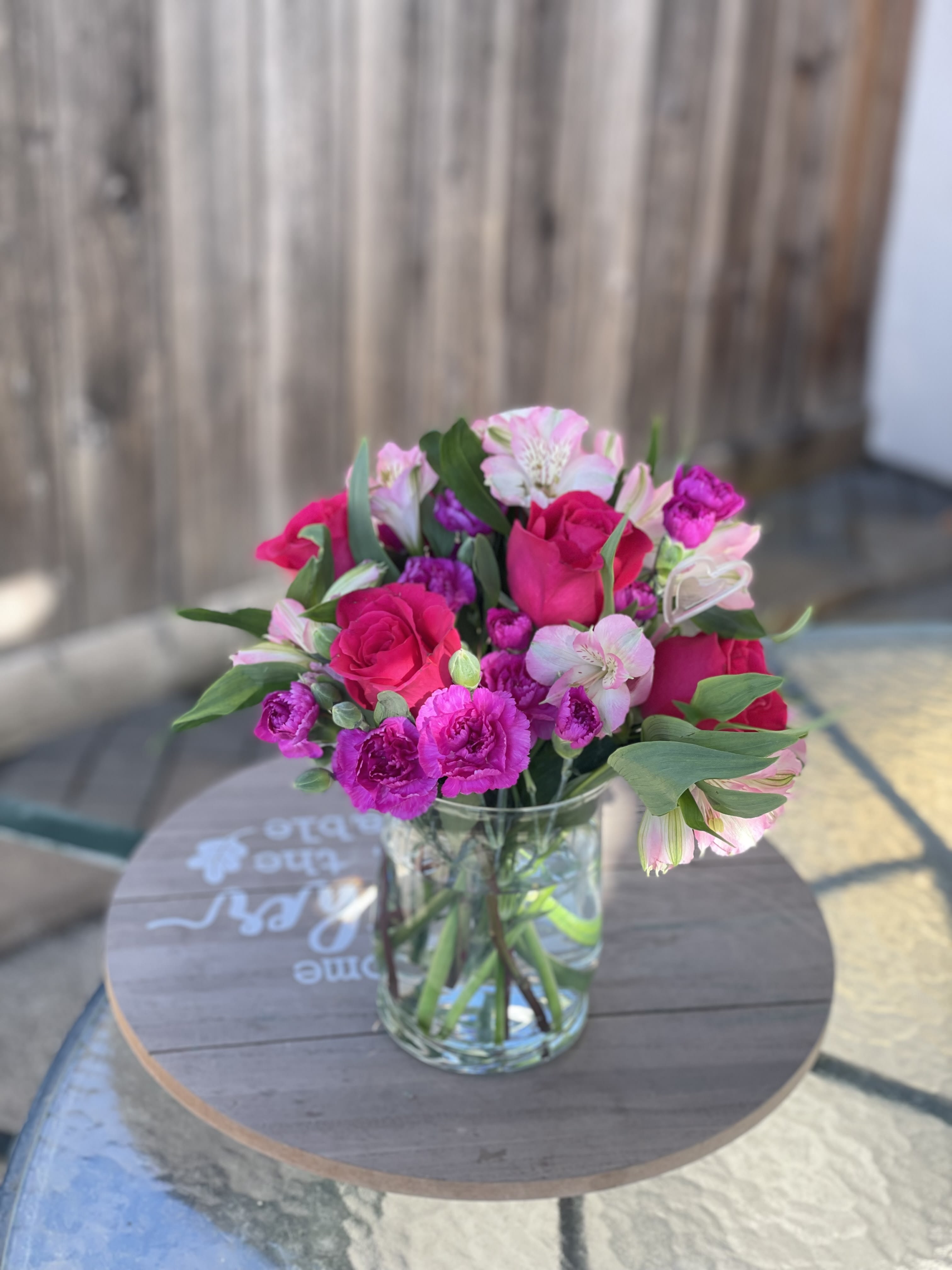 Pink and white bouquet of roses and alstroemeria in a clear glass vase