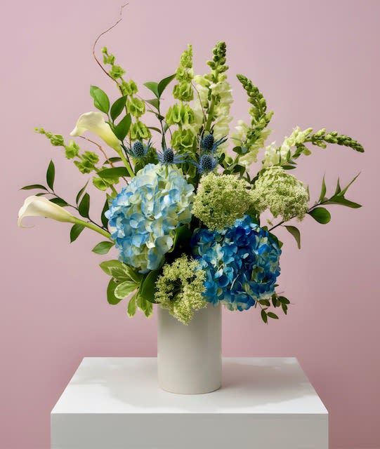 Skyline Bloom  - A modern and refined arrangement in serene shades of white and blue, thoughtfully designed to evoke the calm beauty of an open sky. Clean lines and soft textures come together in this contemporary piece, offering balance, elegance, and quiet sophistication—perfect for any occasion.