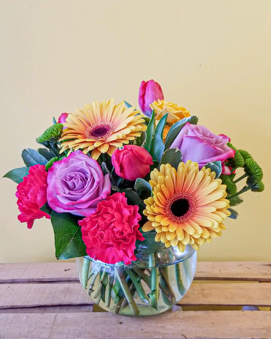 Mixed bouquet of pink and lavender flowers in a glass vase
