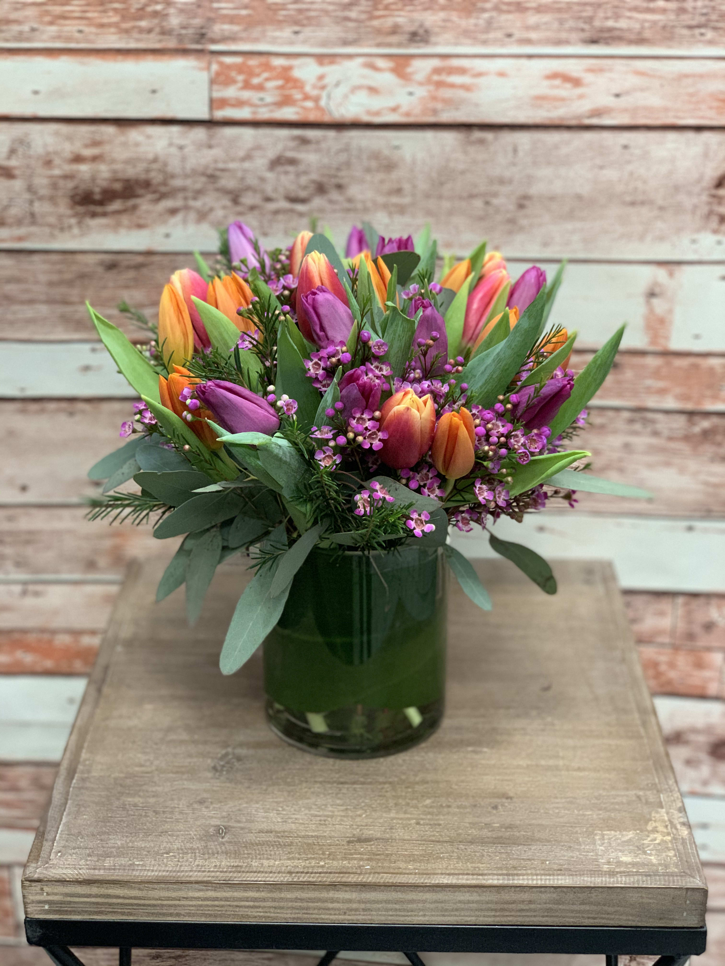 Colorful tulip bouquet in a green glass vase