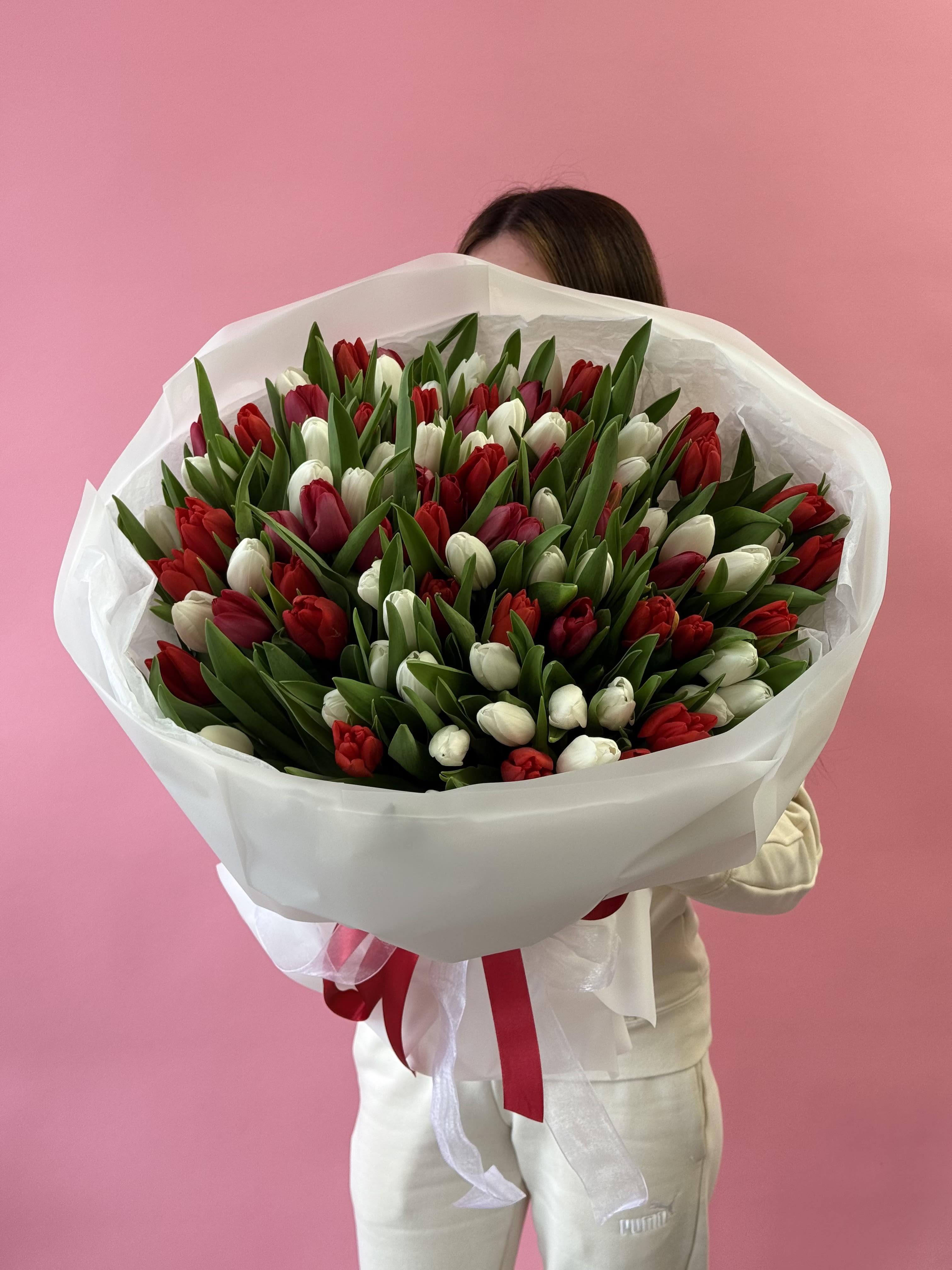 Large bouquet of red and white tulips wrapped in white paper