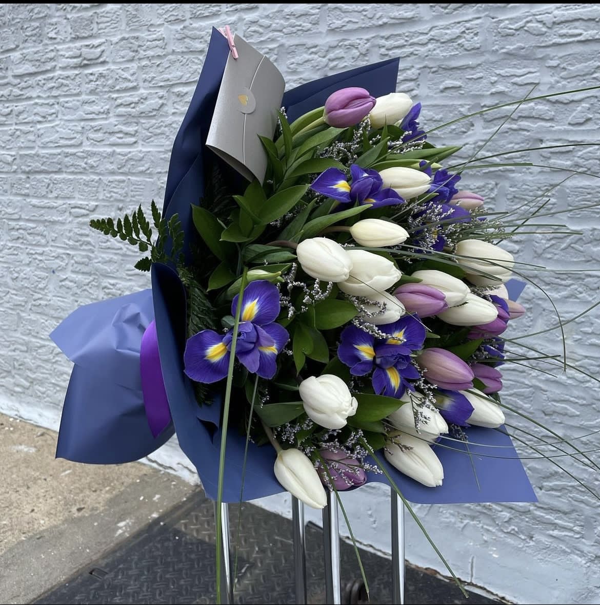 Bouquet of purple and white tulips with iris in blue wrapping