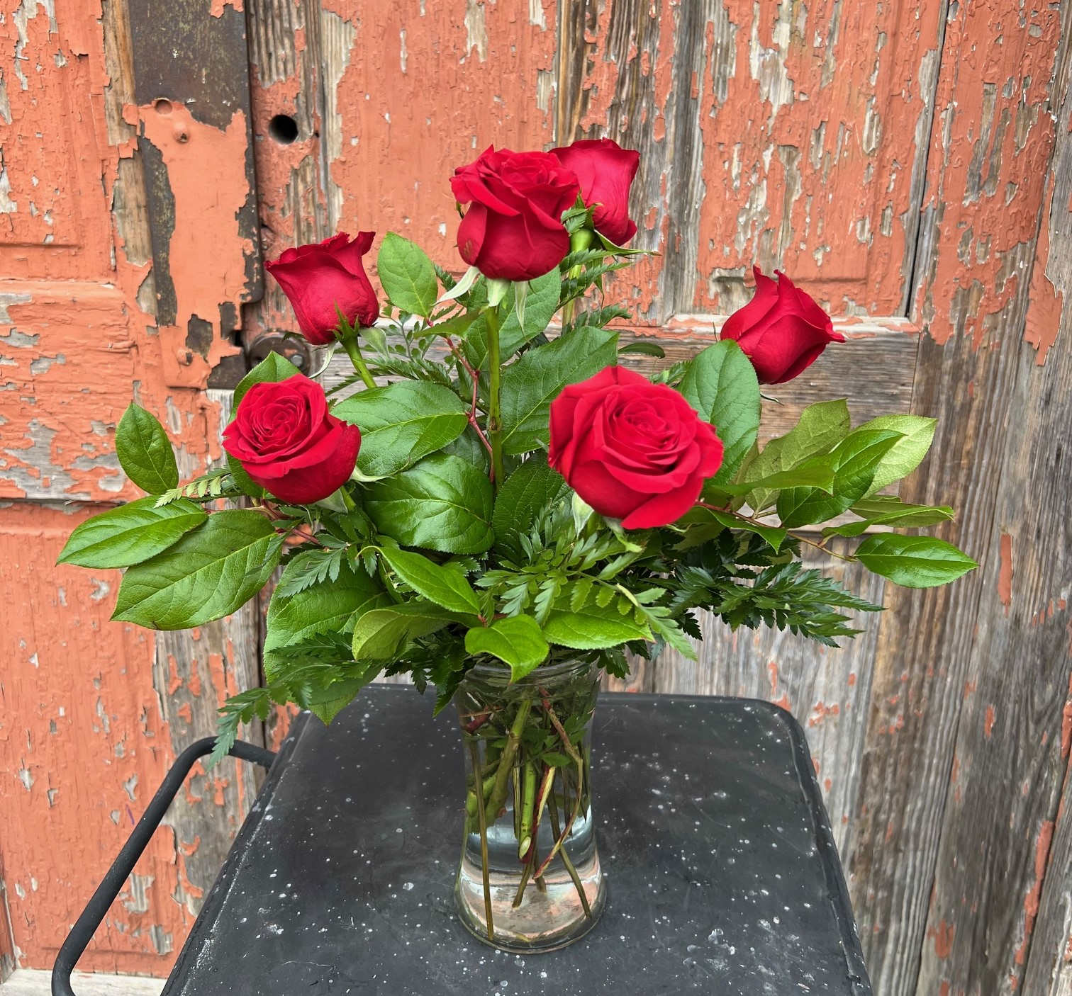Red roses arranged in a clear glass vase