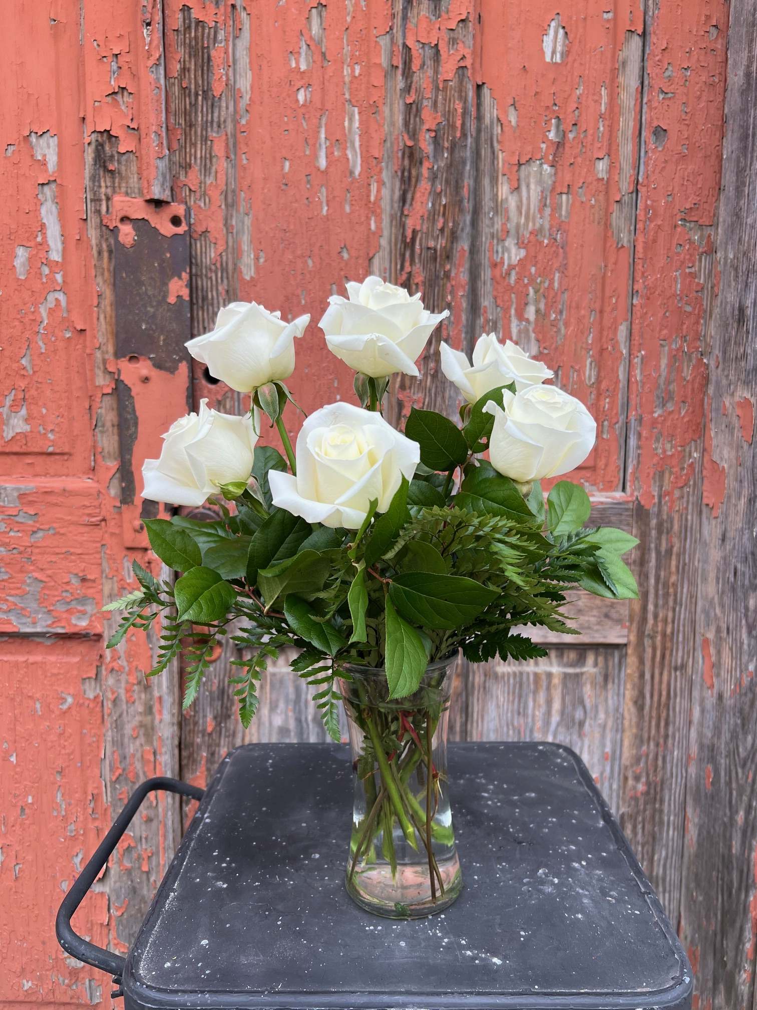 White roses arranged in a clear glass vase