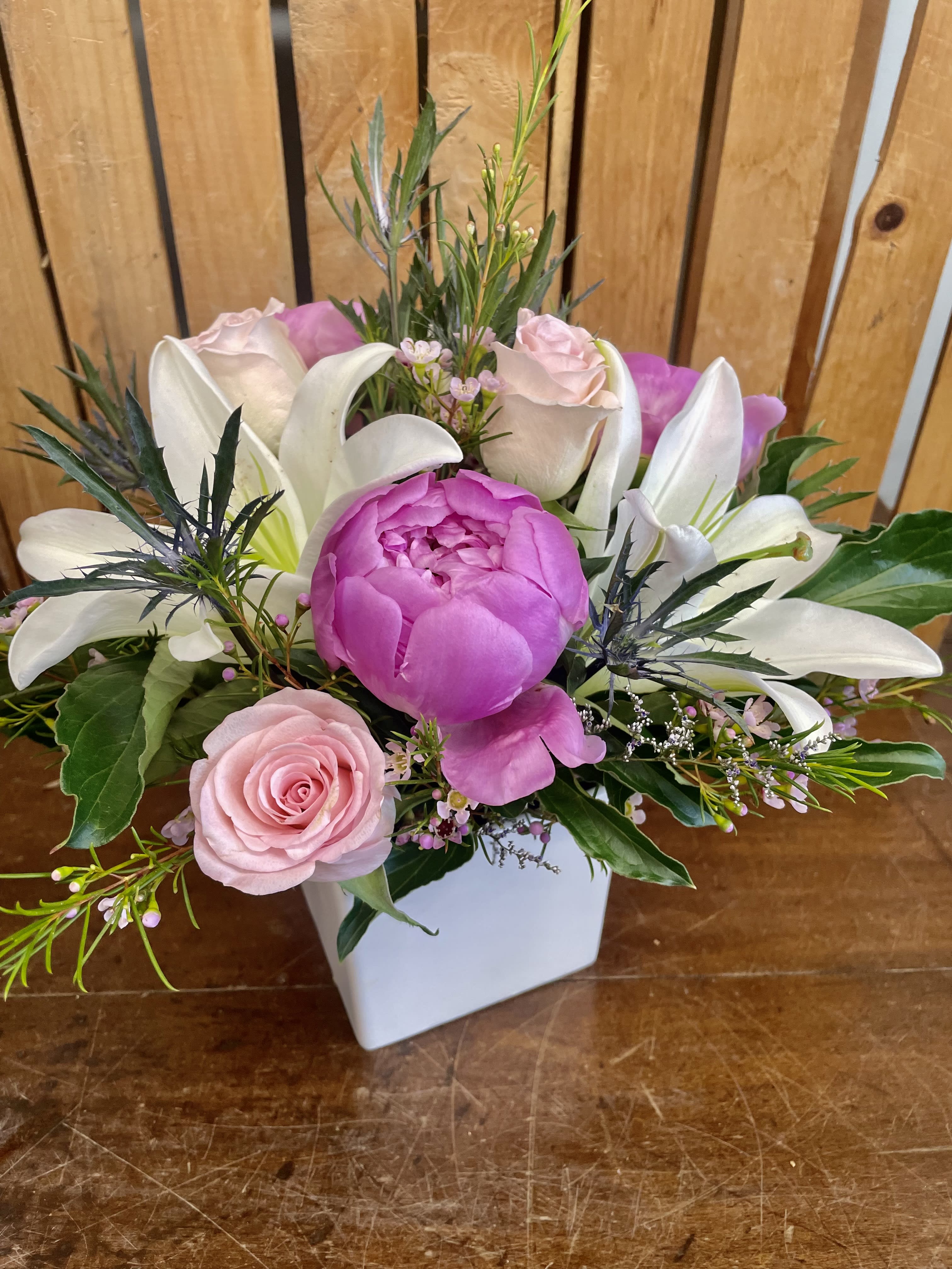 Majestic Beauty - This gorgeous flower arrangement features sweet pink peonies, elegant lilies, and stunning pink roses, beautifully displayed in a white ceramic cube vase.