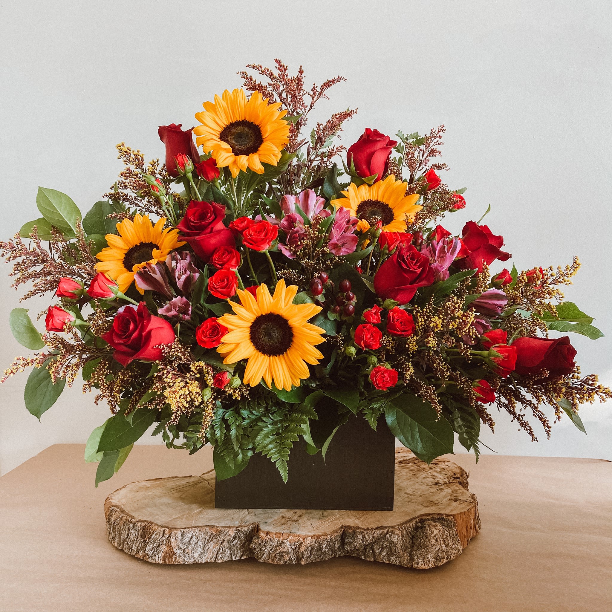 Pixie - Theme Colors: Shades of: Yellow, and Red.  Featured Blooms:  Sunflowers, Red Roses, Alstroemerias, &amp;Greenery.  HK Flowers have a uniqueness of florals and seasonal blooms, certain flowers or colors may not be available as each season affects the availability, color, size, and shape of each floral bloom. Some flowers may be substituted accordingly.  Photos are used as a reference for the color palette and is NOT indicated of the final product. We ask for your trust in us that we will pick out the best seasonal available blooms, while still capturing the arrangements' theme and colors mentioned above.