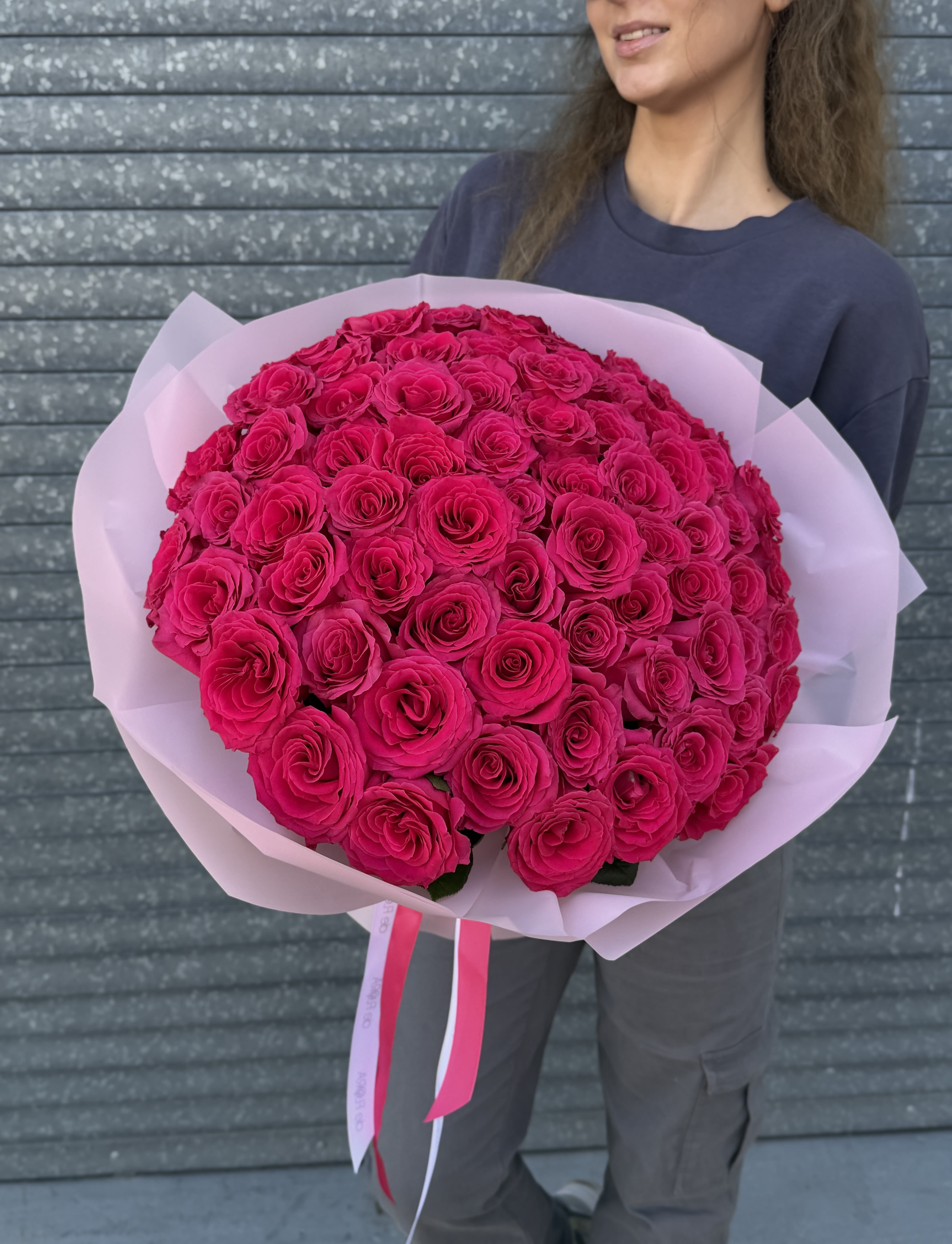 Large bouquet of hot pink roses wrapped in pale pink paper
