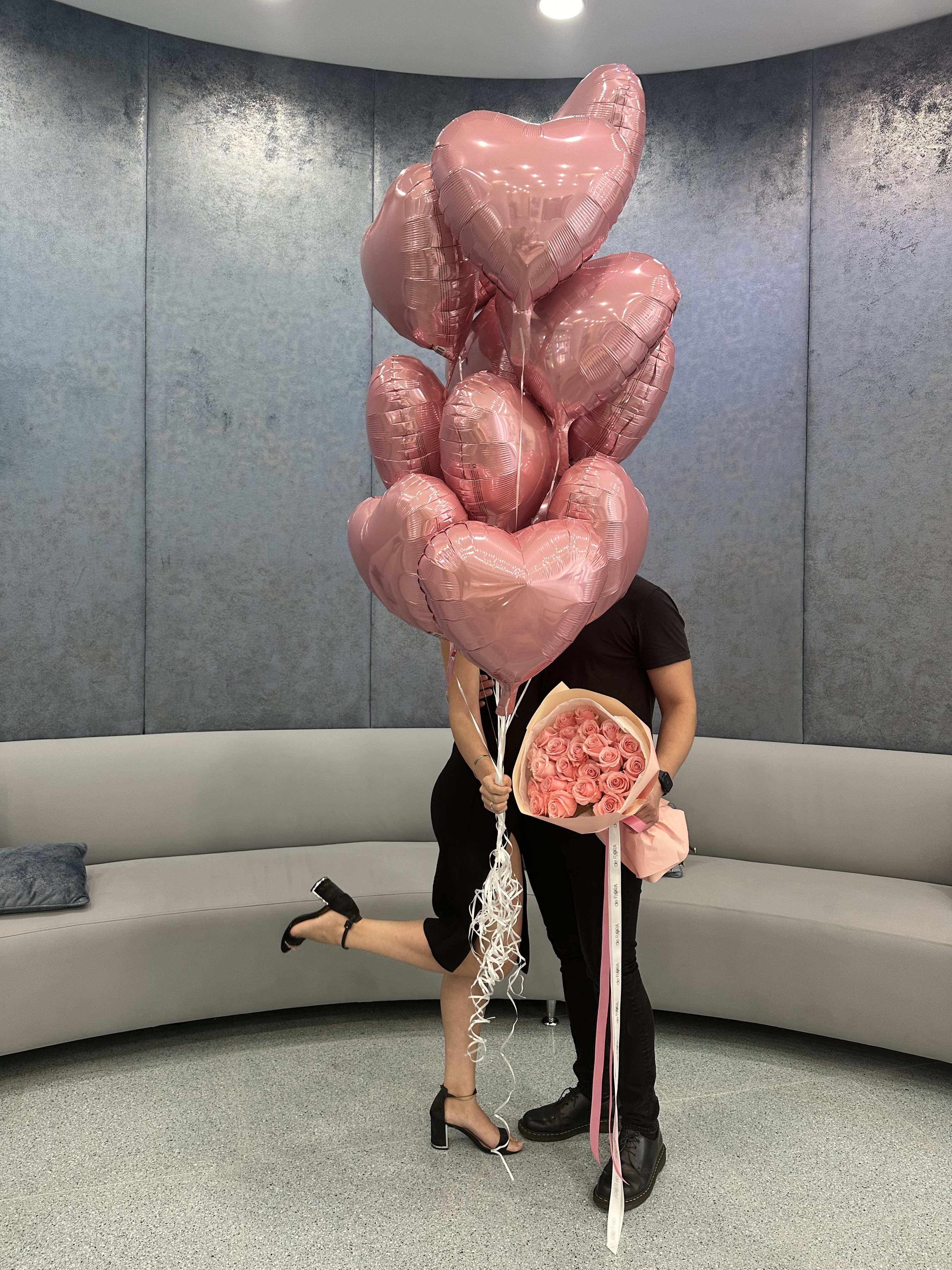 Pink heart balloons with a bouquet of pink roses