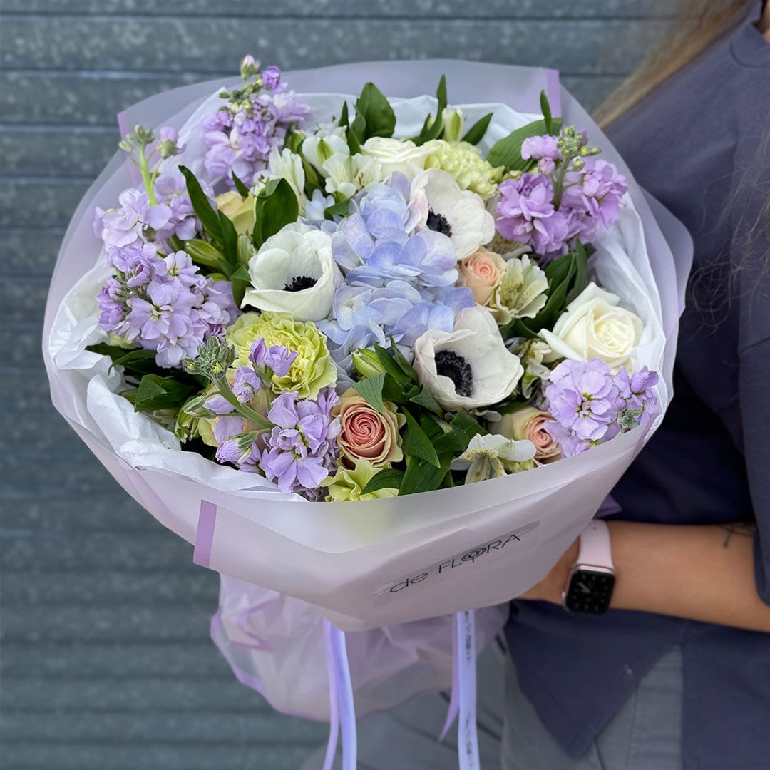 Amour Pastel - Inspired by soft coastal light and refined femininity, this bouquet combines hydrangea clouds, creamy roses, fresh greenery, and romantic lilac blooms.  It feels airy, fresh, and effortlessly chic — perfect for a confident woman with graceful taste.