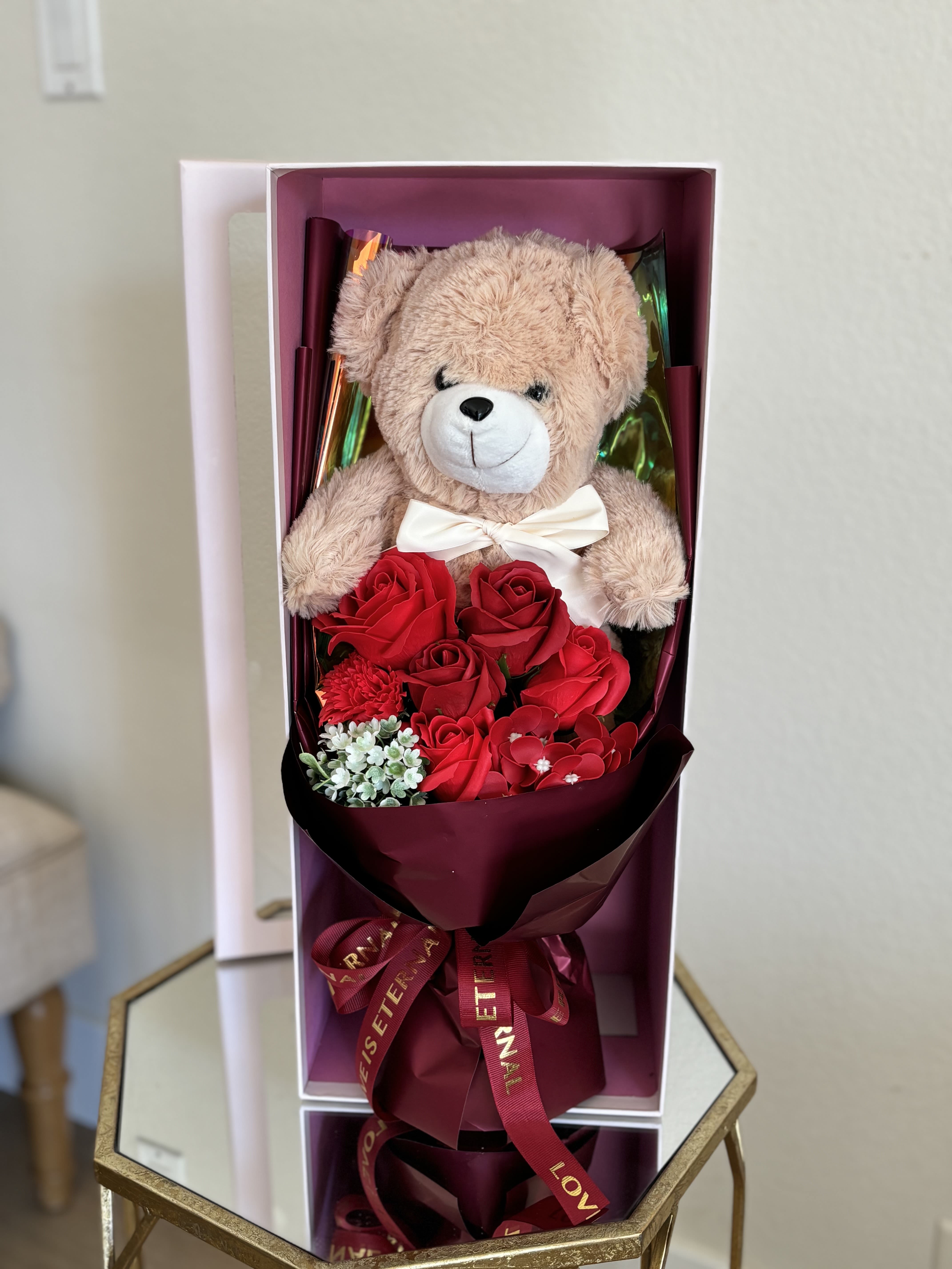 Teddy bear with red roses in a gift box