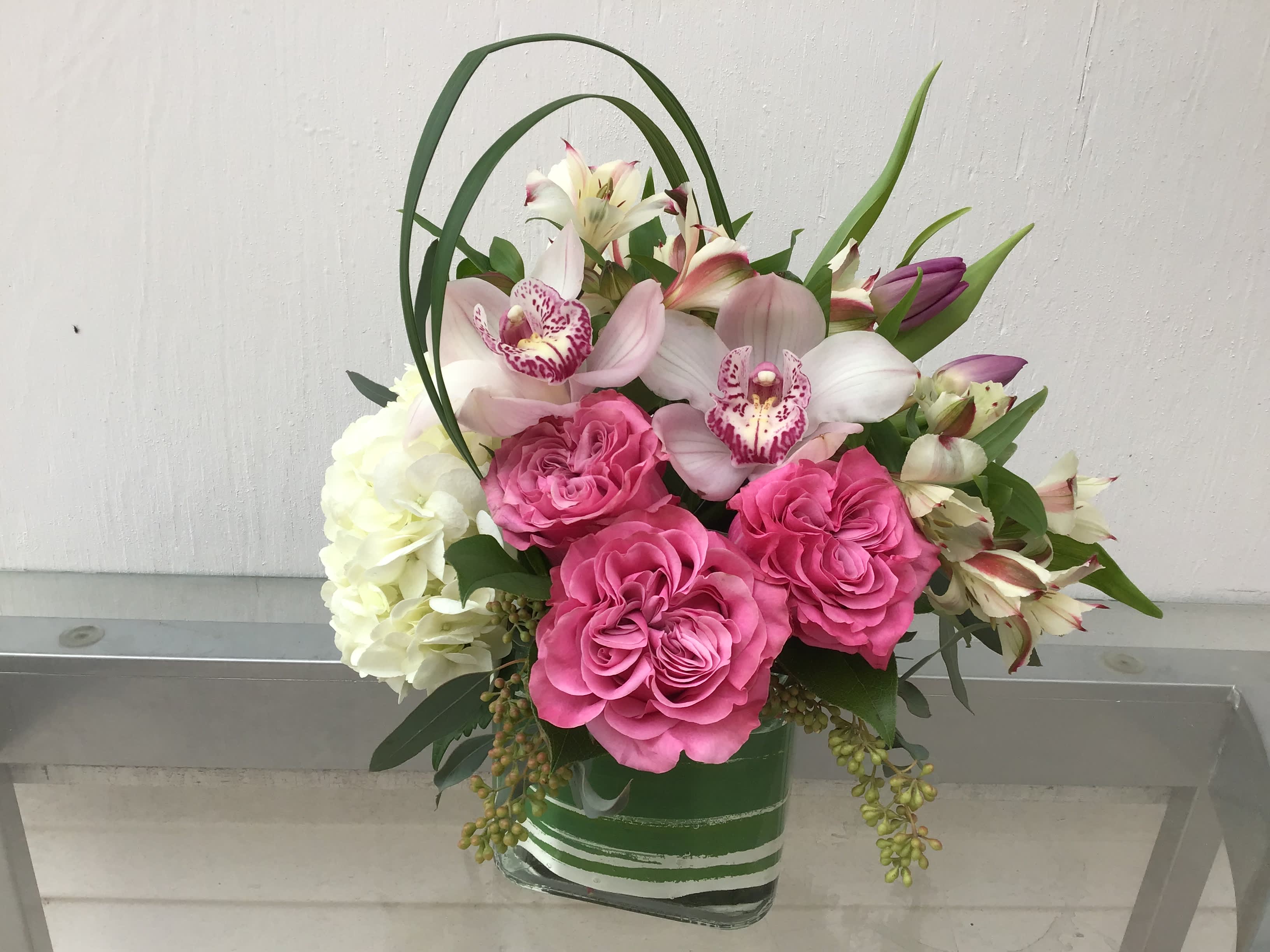 Mandalay - Cube With a Mound of White Hydrangea, Roses, tulips, Cymbidium Orchids, Alstroemeria and loops of lily grass. Will be available the week of Mother's Day. Call to place order for Mandalay
