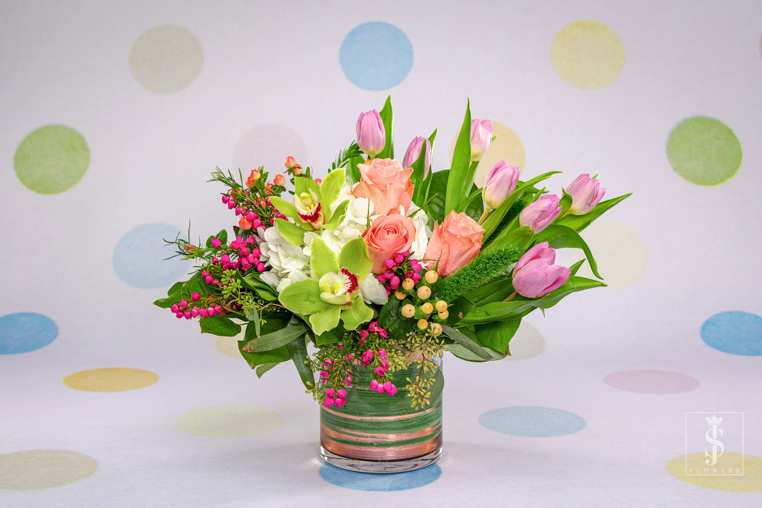 Blushing Beauty  - This Lush and whimsical blush bouquet is sure to take your breath away. With white hydrangea, blush roses, green cymbidium blooms, and tulips rest atop clouds of hydrangea. 