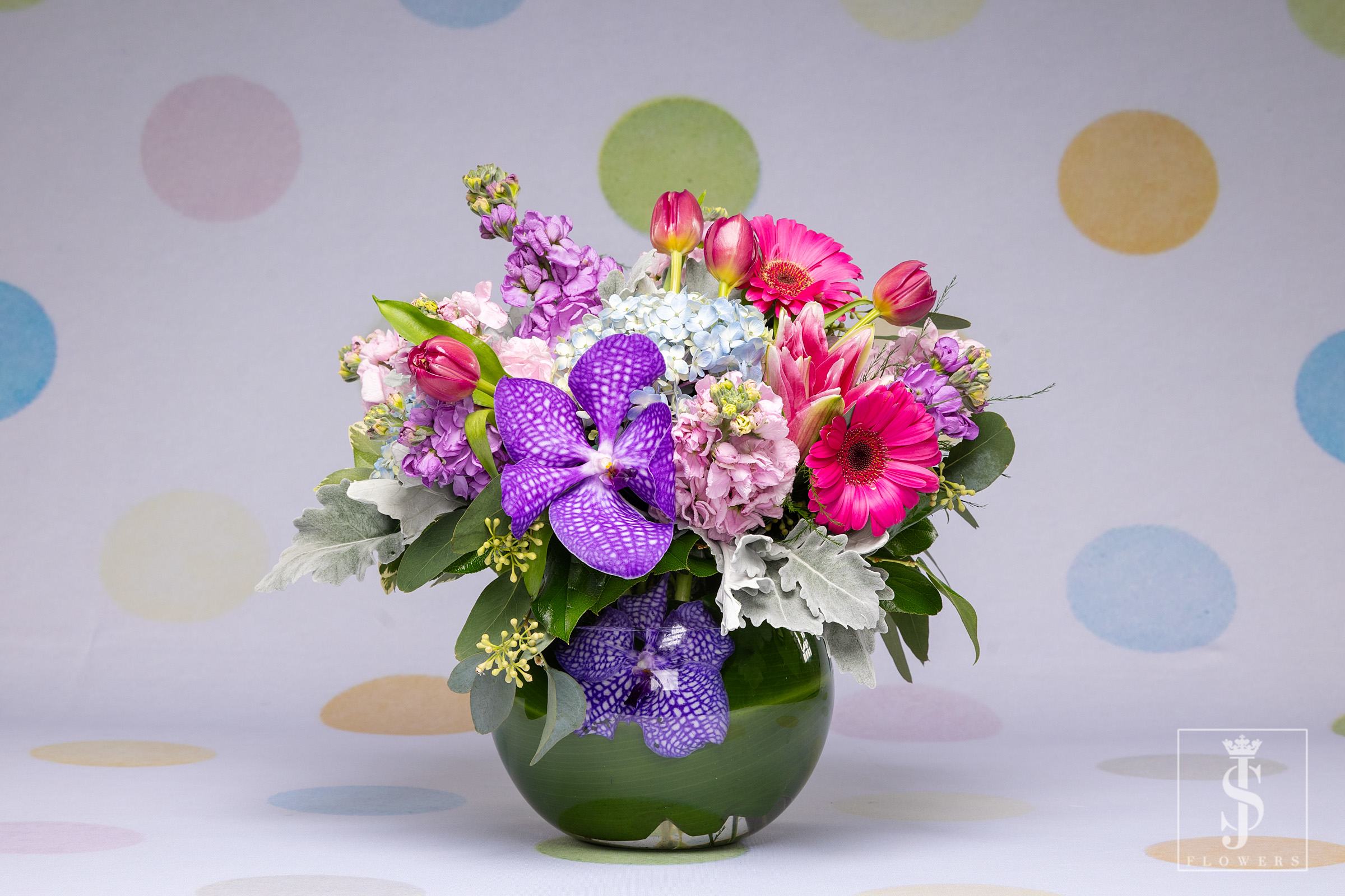 Mom Pretty Pastels  -  Introducing Pretty Pastels, a delicate symphony of colors and fragrances!   This enchanting floral arrangement features the elegance of purple orchids, complemented by the soft and silvery foliage of dusty miller. The gentle hues of lavender stock, and the enchanting combination of purple, pink, and blue hyacinths, create a captivating play of pastel tones.  Not only is Pretty Pastels a visual delight, but it also comes with a heavenly fragrance that will fill the air with sweet scents.