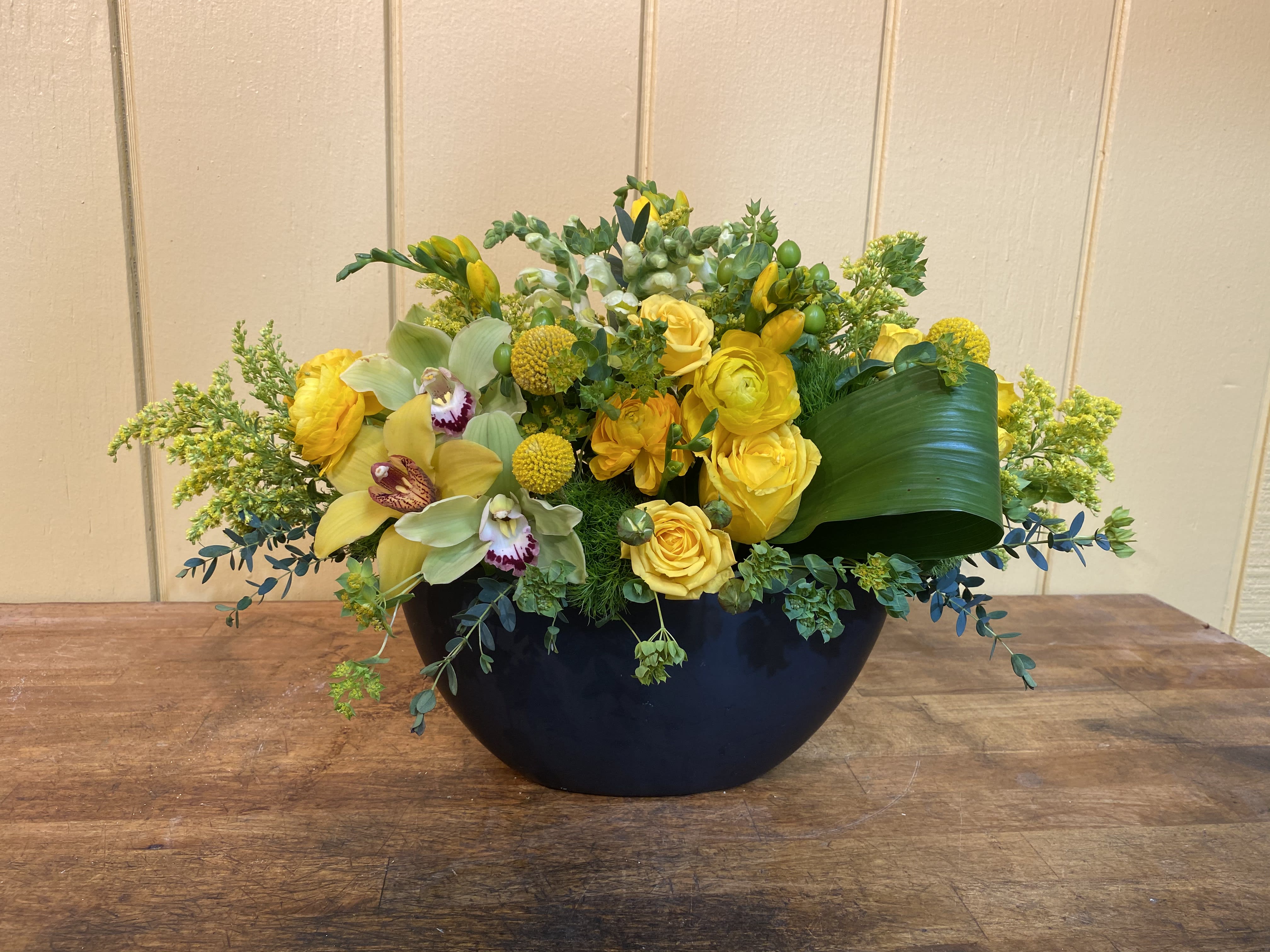 Yellow floral arrangement in a black bowl vase