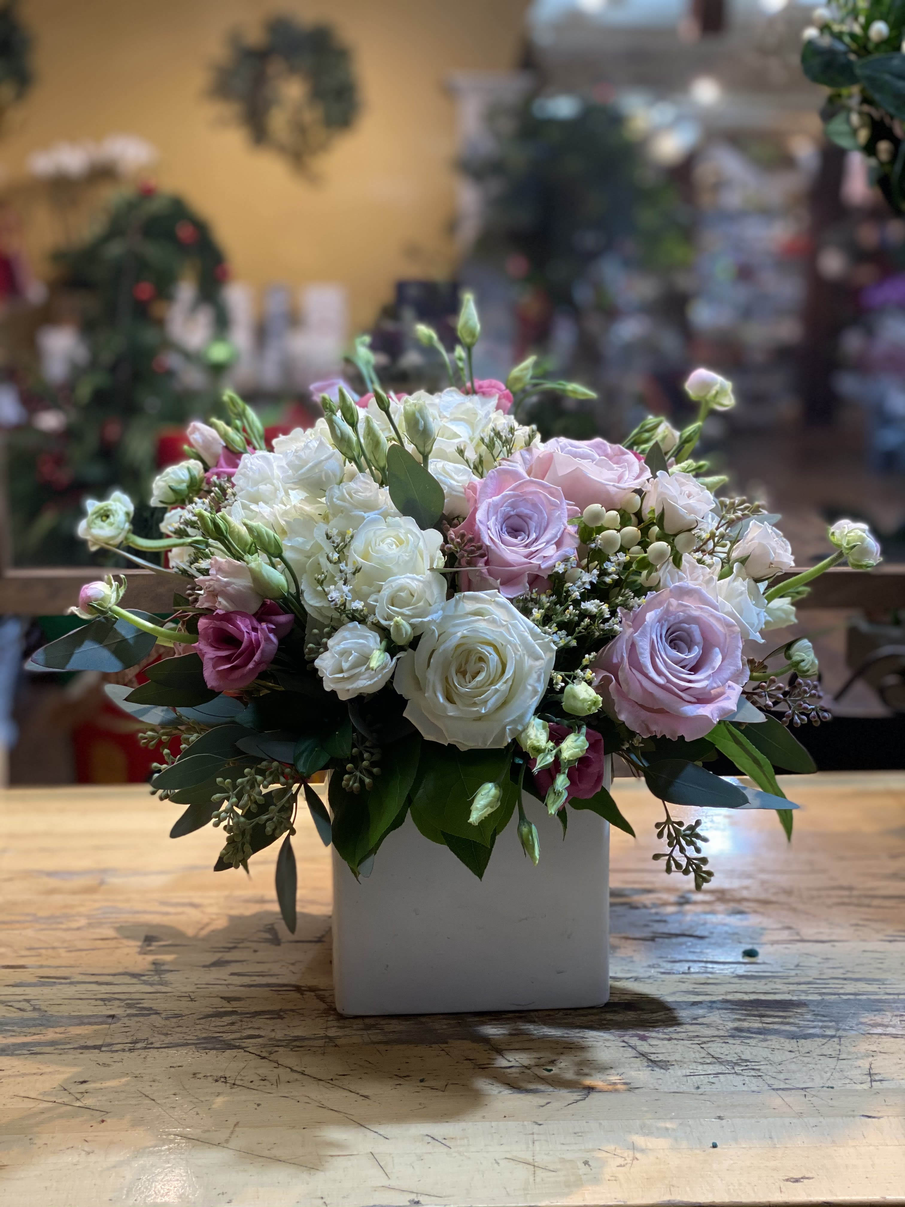 Bouquet of pink and white roses in a white square vase