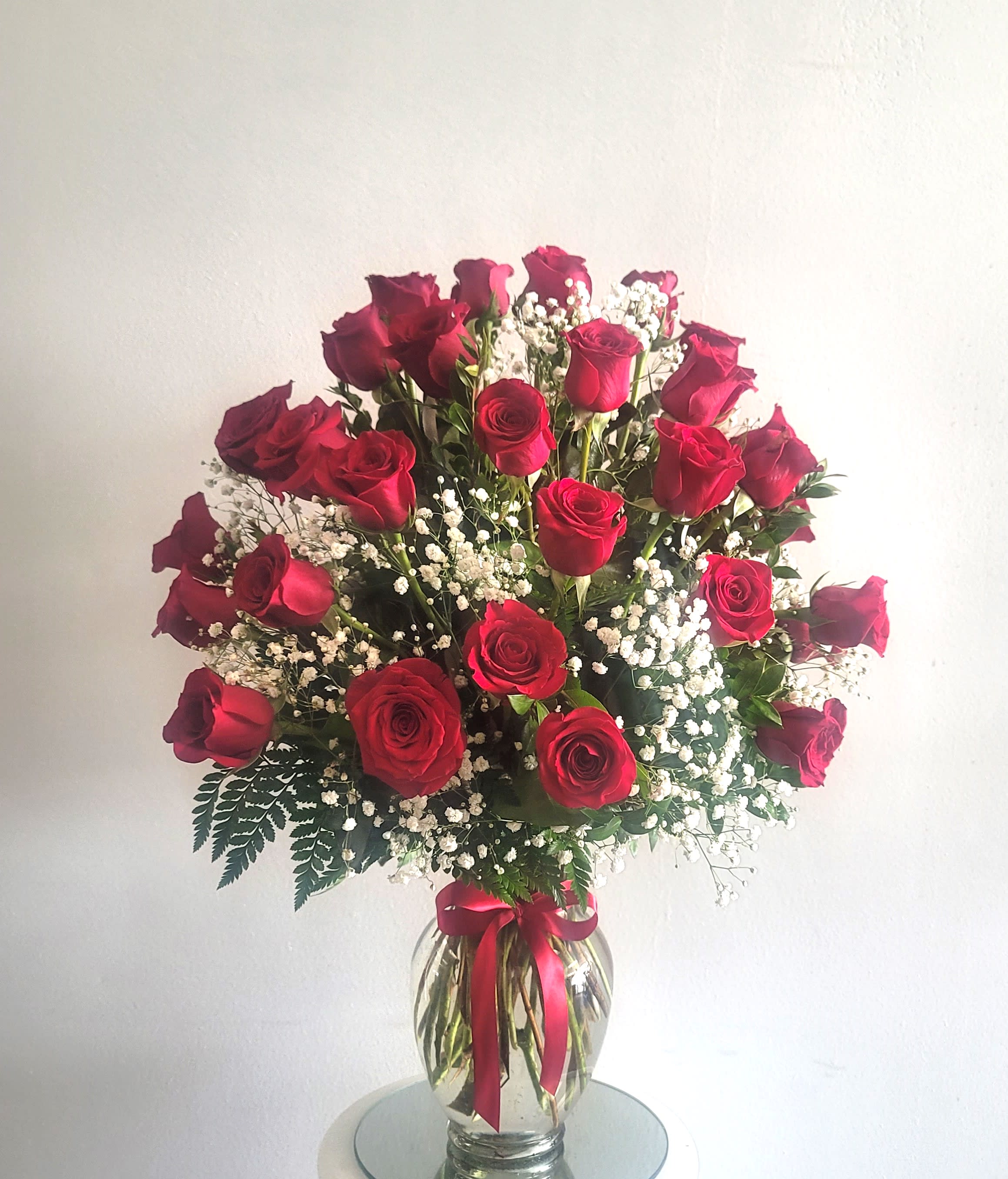 Bouquet of red roses with baby's breath in a glass vase