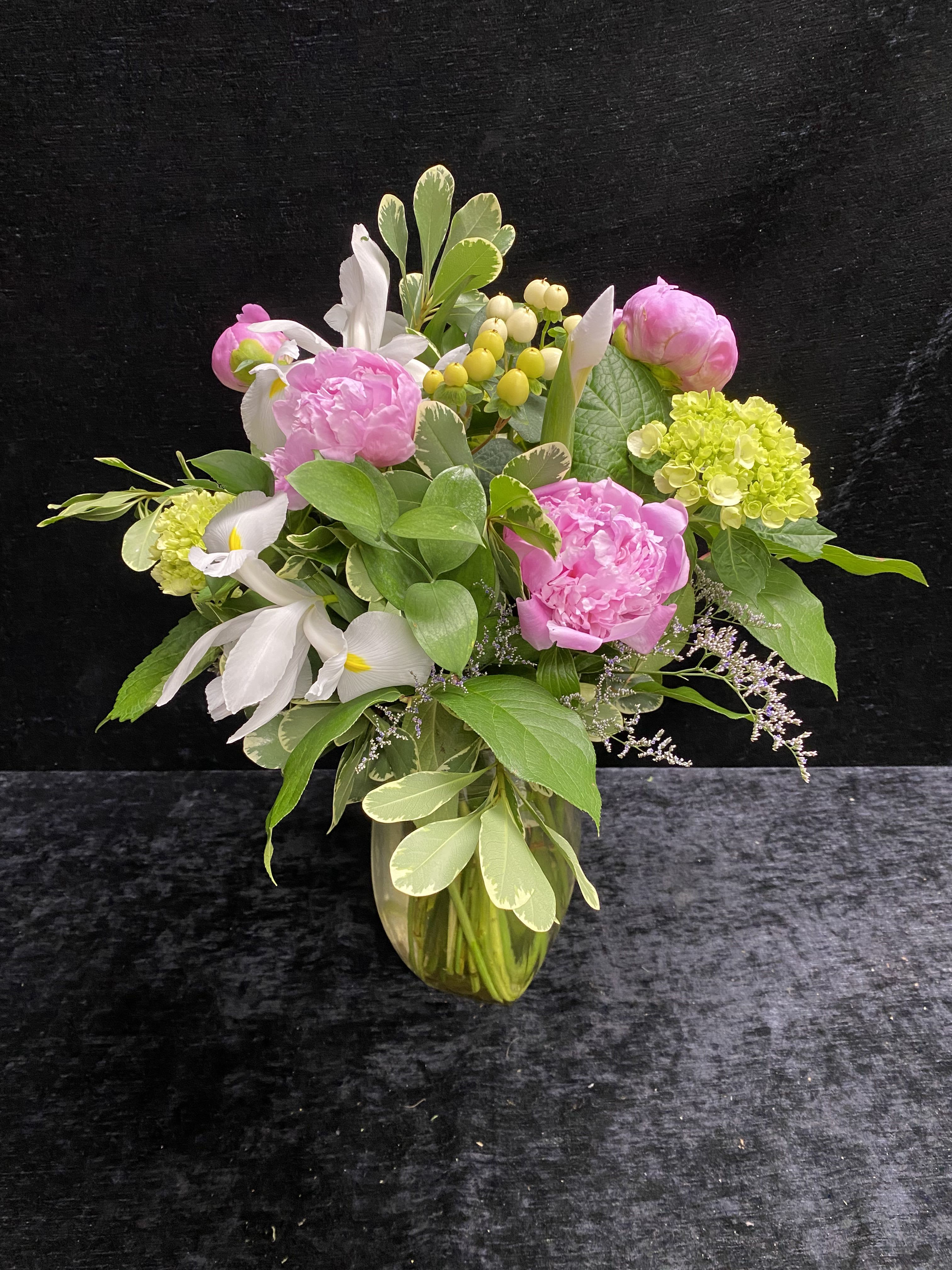 Perfect Peony for Mom - Big, romantic pink peonies take center stage in this Mother's Day-ready flower arrangement, paired with elegant white iris for a soft, sophisticated feel.  Send this when you want her to feel cherished and celebrated; the palette of pink, white and green reads as warm and uplifting. The arrangement arrives ready to display in the included clear glass vase. Keep blooms in fresh water, away from direct heat, and they will continue to bring a soft, garden-fresh presence to her home.