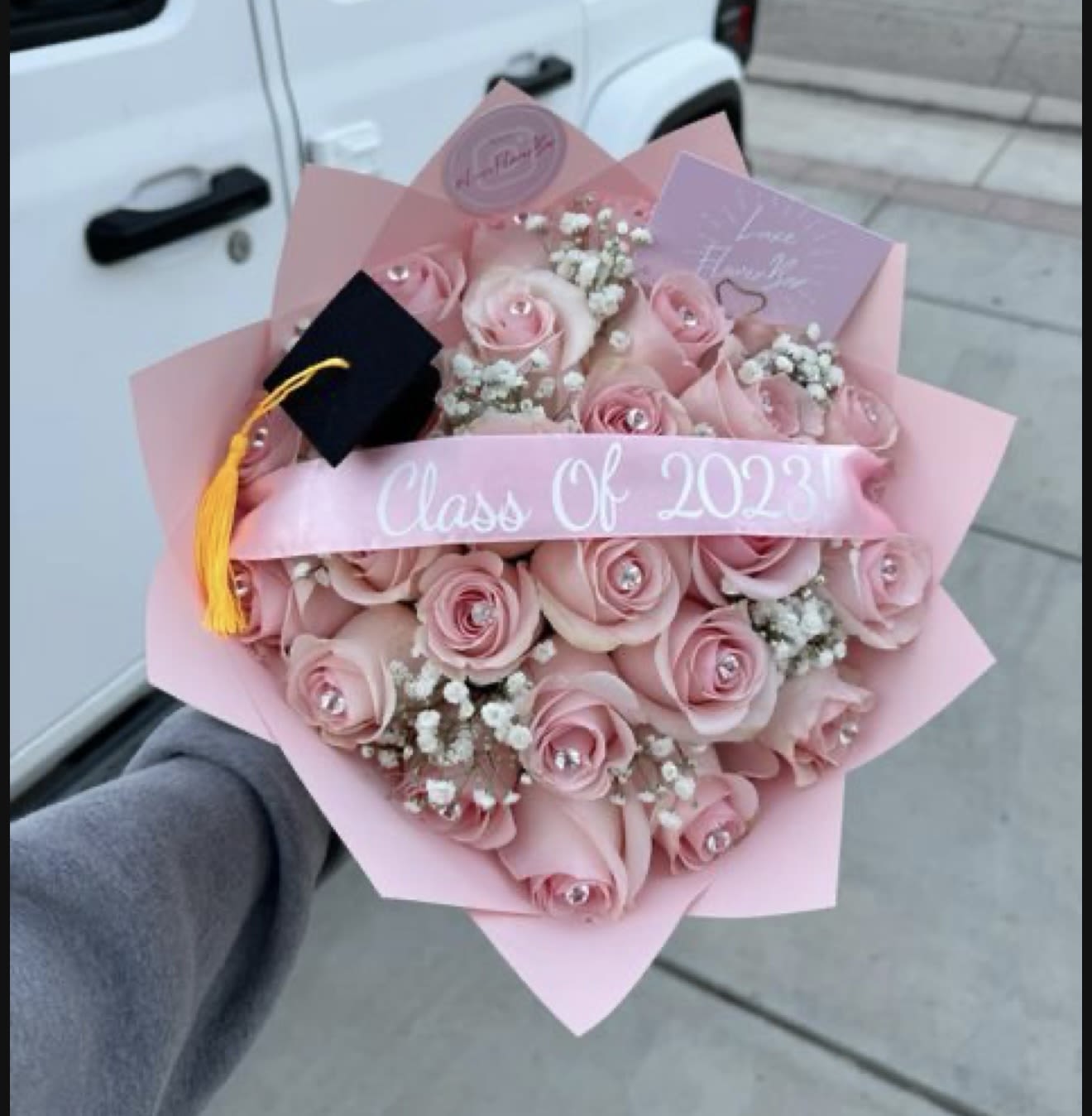 Pink rose bouquet with a graduation cap and Class of 2023 ribbon
