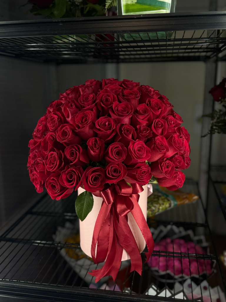 Large bouquet of red roses tied with a satin ribbon in a pale box