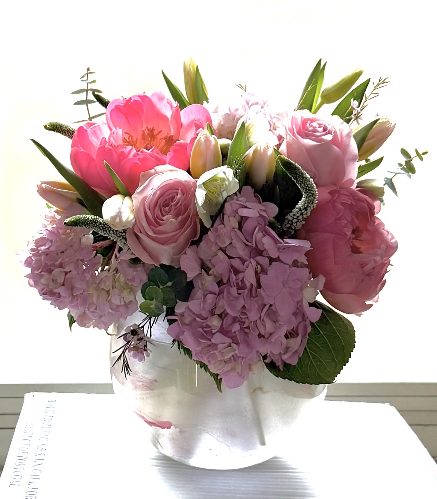 Coral Peony Romance – Valentine’s Day Floral Arrangement | Washington DC - Make a bold romantic statement this Valentine’s Day in Washington, DC with Coral Peony Romance, a luxurious floral arrangement highlighting stunning coral peonies at their peak. These lush, ruffled blooms are paired with soft blush roses, delicate pink hydrangea, and fresh seasonal accents, creating a rich and romantic composition.  Coral peonies are prized for their vibrant color, fullness, and symbolism of love, passion, and prosperity—making them the perfect centerpiece for Valentine’s Day gifting. Designed in a luminous pink, pearl-toned vase, this arrangement feels both modern and timeless.   Details: 	•	Featured premium coral peonies 	•	Blush roses &amp; pink hydrangea accents 	•	Romantic pink and coral palette 	•	Luxury keepsake vase 	•	Designed for Valentine’s Day in 