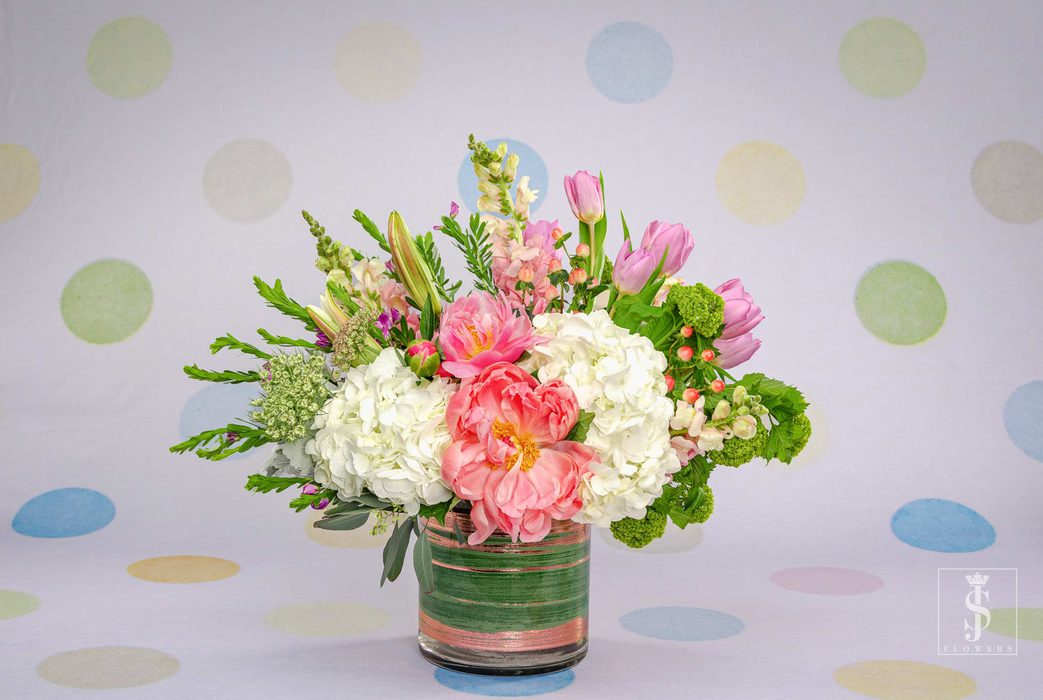 Pink Peonies and Tulips  - As fragrant as it is graceful, this stunning design calls upon the softest shades of ballerina pink. crisp white hydrangea, pink peonies, and tulips creating a lush abundance. An assortment of pink gravel can be seen submerged within the interior of the cylinder glass vase.
