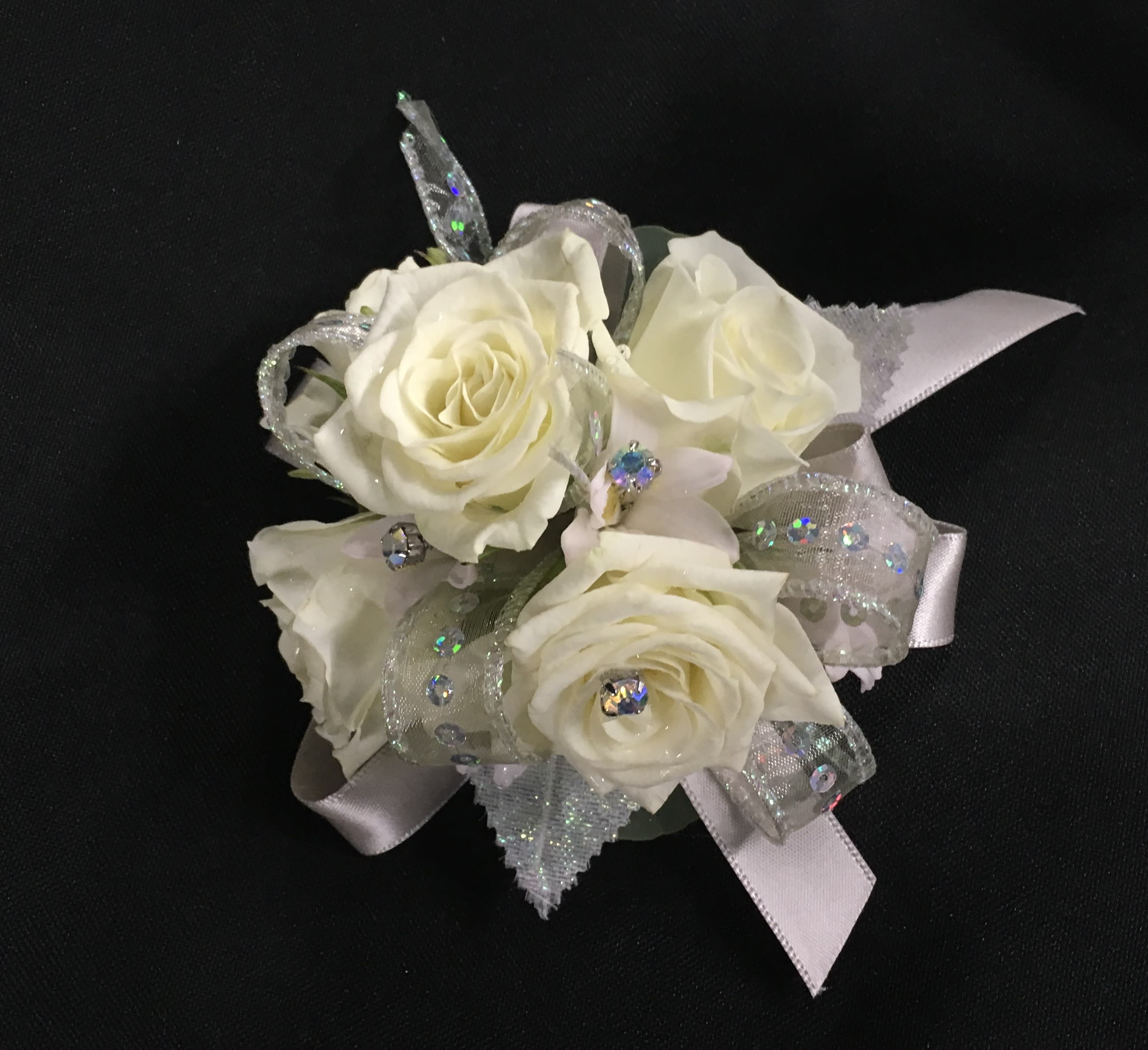 White rose corsage with silver ribbon and rhinestone accents