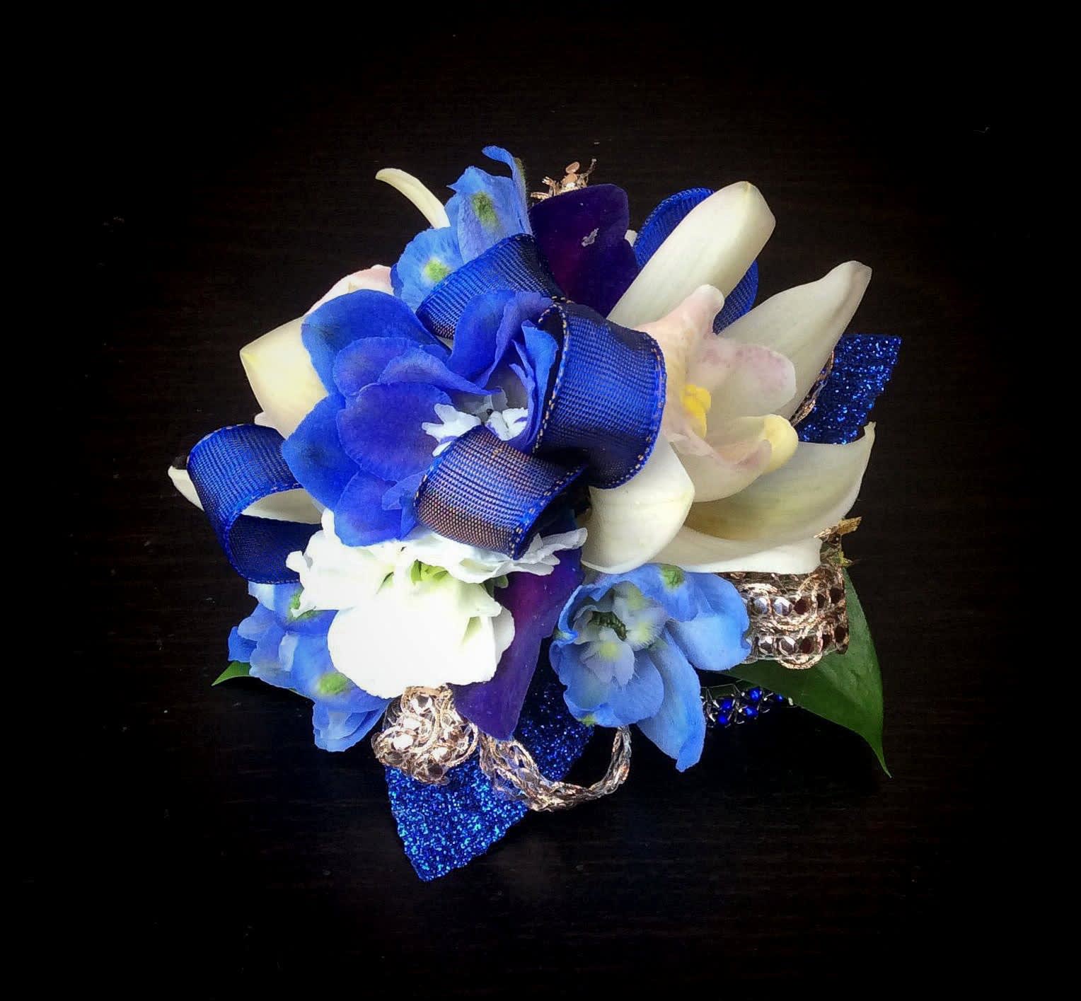 Blue and white floral corsage with ribbon on a dark background
