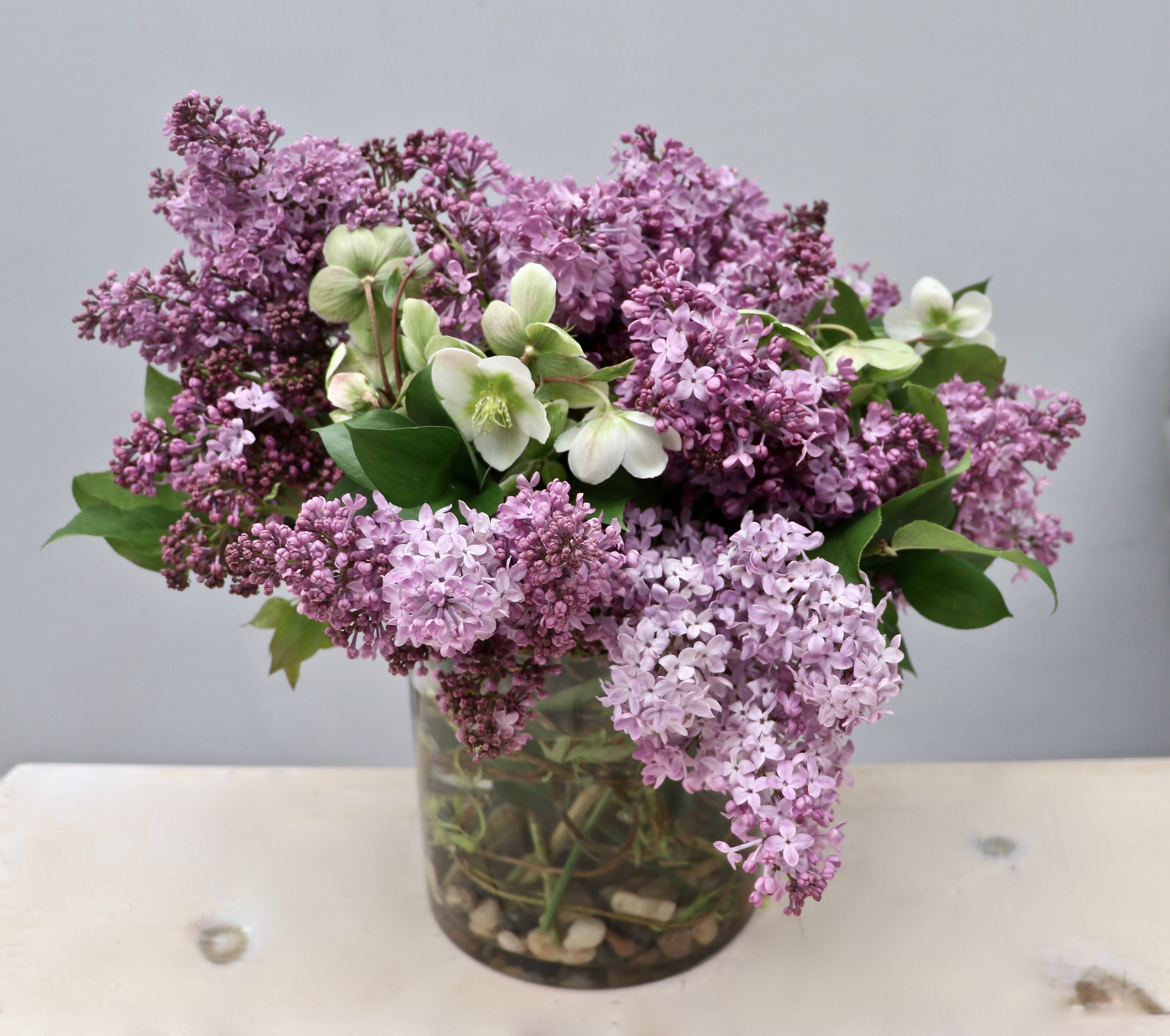 Lilac and white flowers arranged in a glass vase