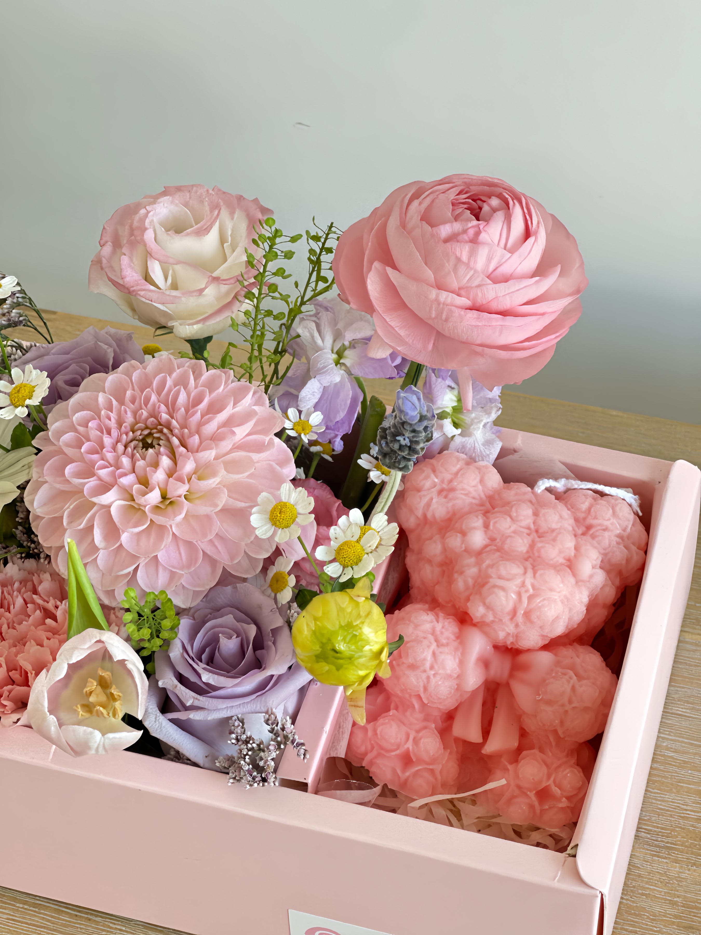 Pink and lavender floral arrangement in a pink box with a heart-shaped plush