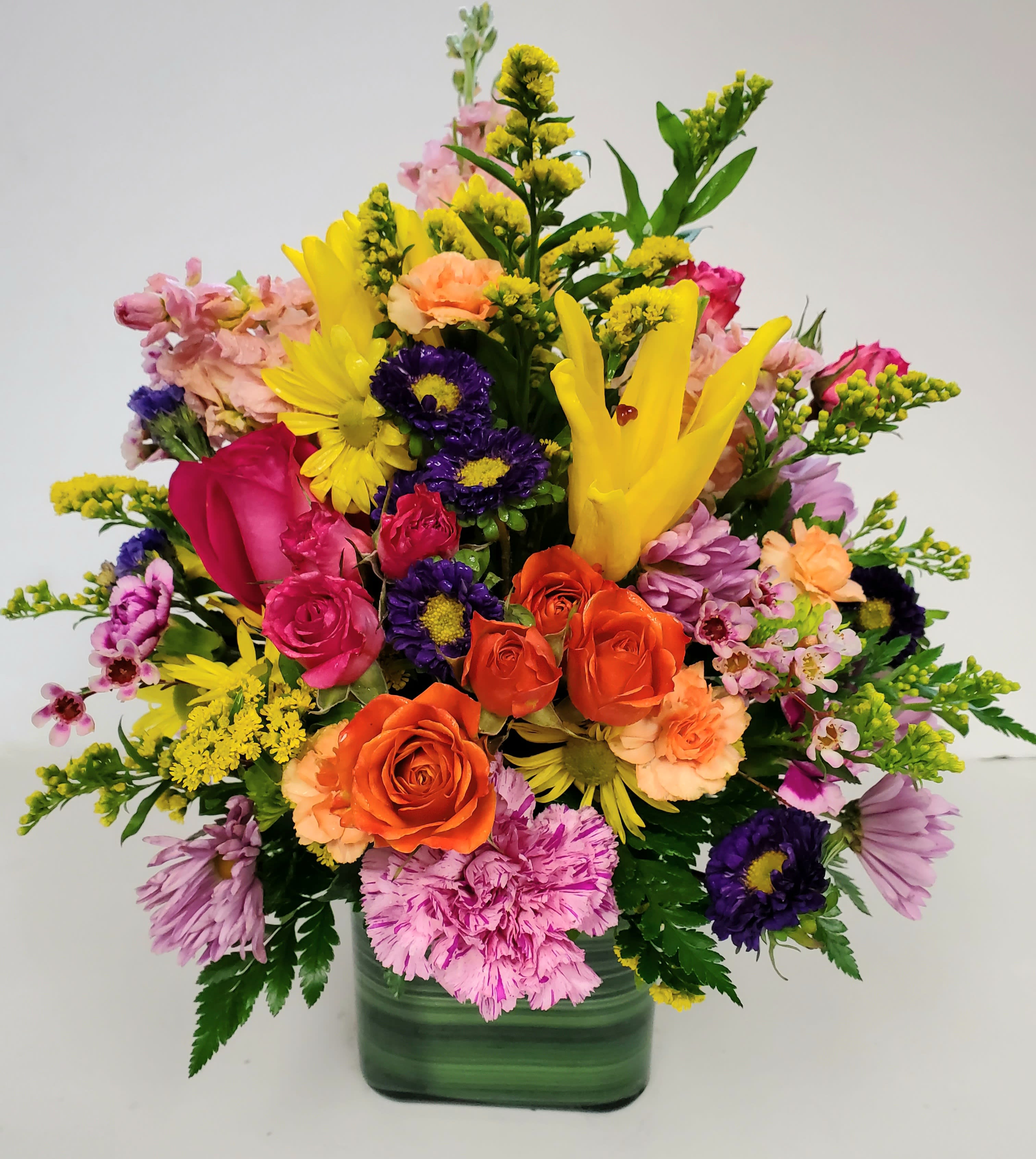 Colorful mixed bouquet in a green glass vase