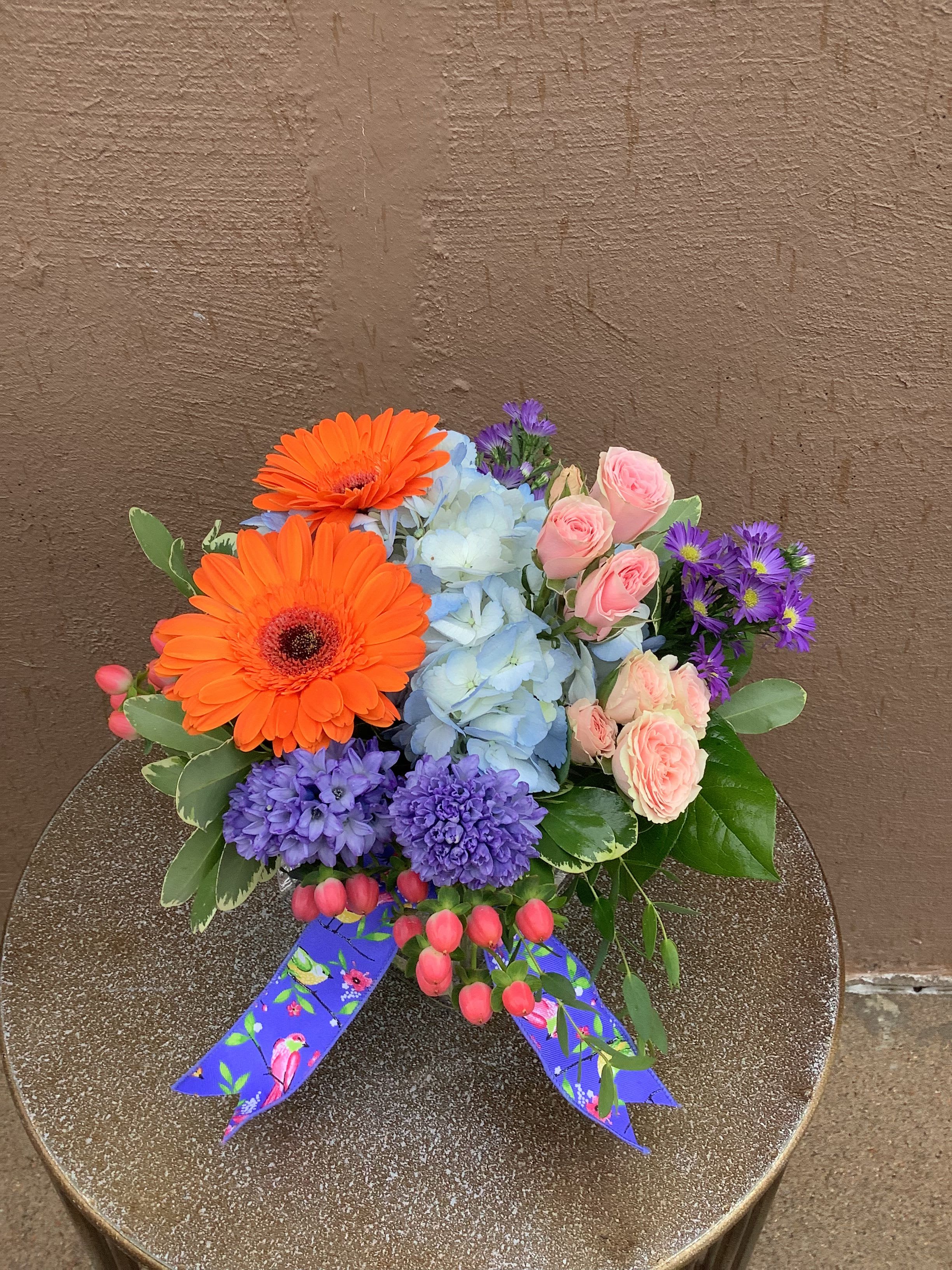 From your favorite  - Bright mixed-color bouquet with gerbera, hydrangea, spray roses, hyacinth and asters, finished with a patterned ribbon.