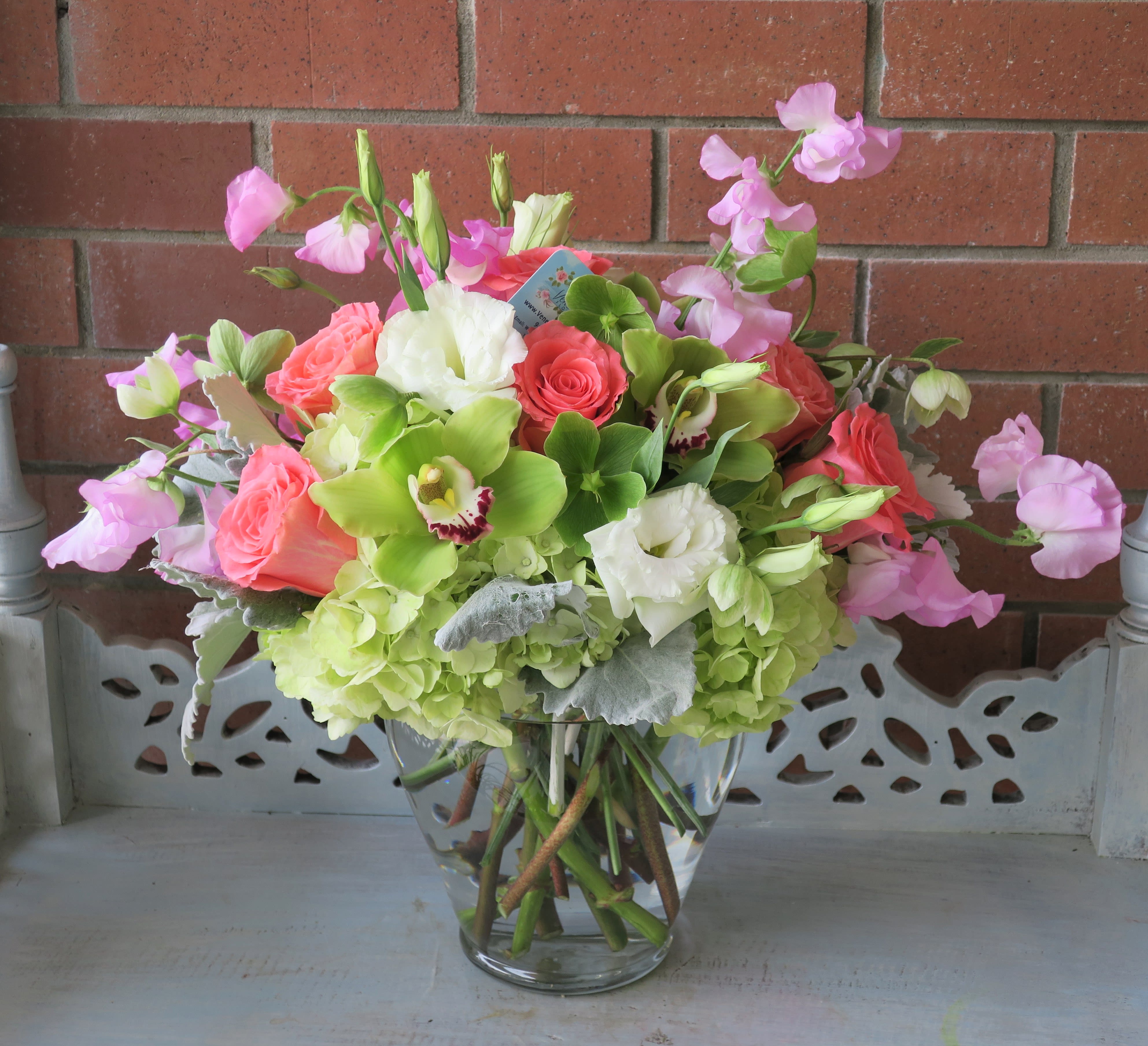 Pink and white floral arrangement in a clear glass vase