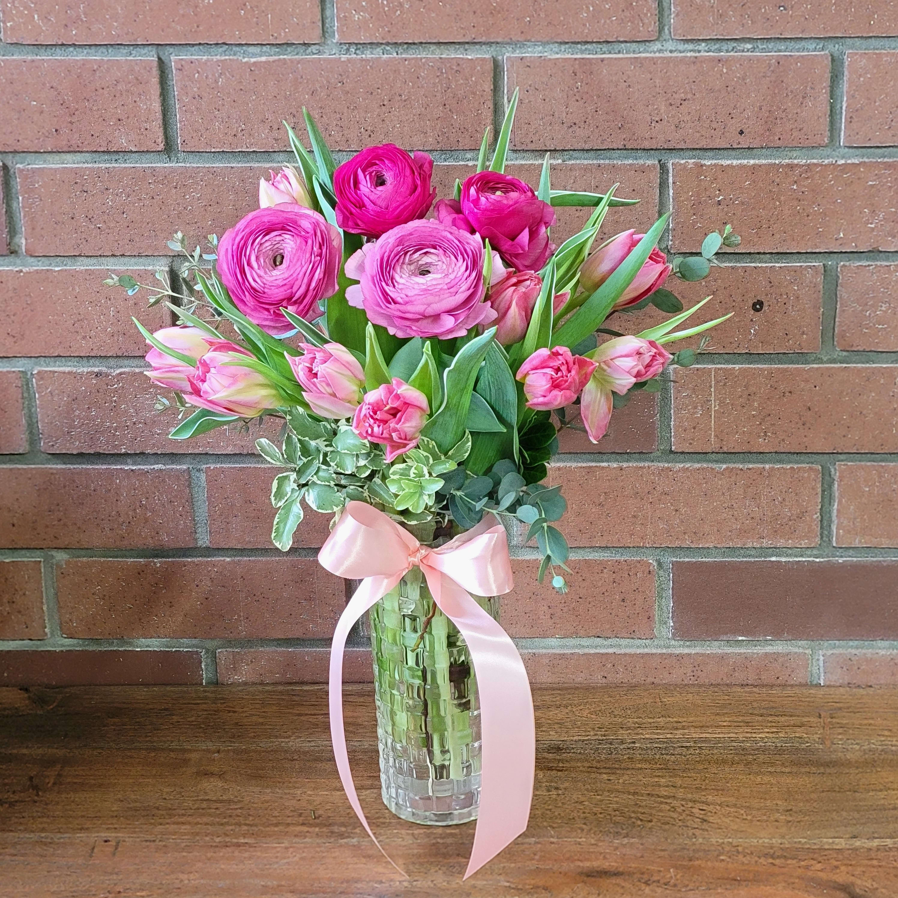 Pink Spring Bouquet - 10 pink or purple tulips with gorgeous pink ranunculus in a sweet fancy heavy glass vase accented with a touch of eucalyptus and mini Italian pitt. Standard 14 blooms. Deluxe 18  blooms. Premium 22  blooms  