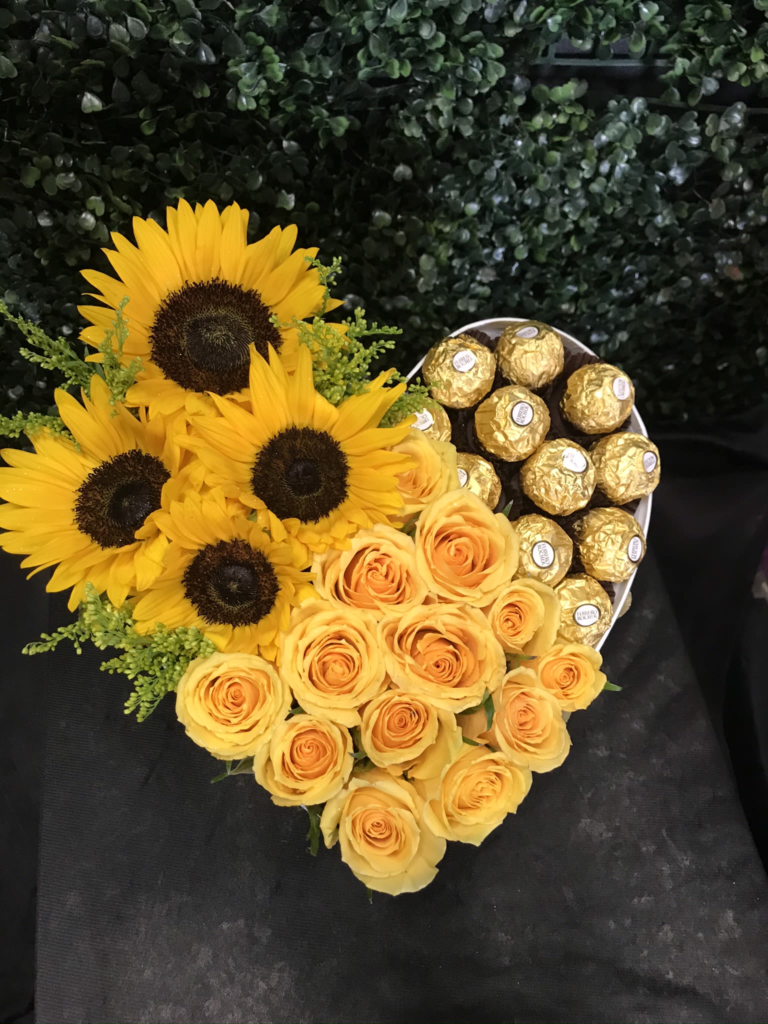 Heart-shaped bouquet of yellow roses and sunflowers with gold chocolates