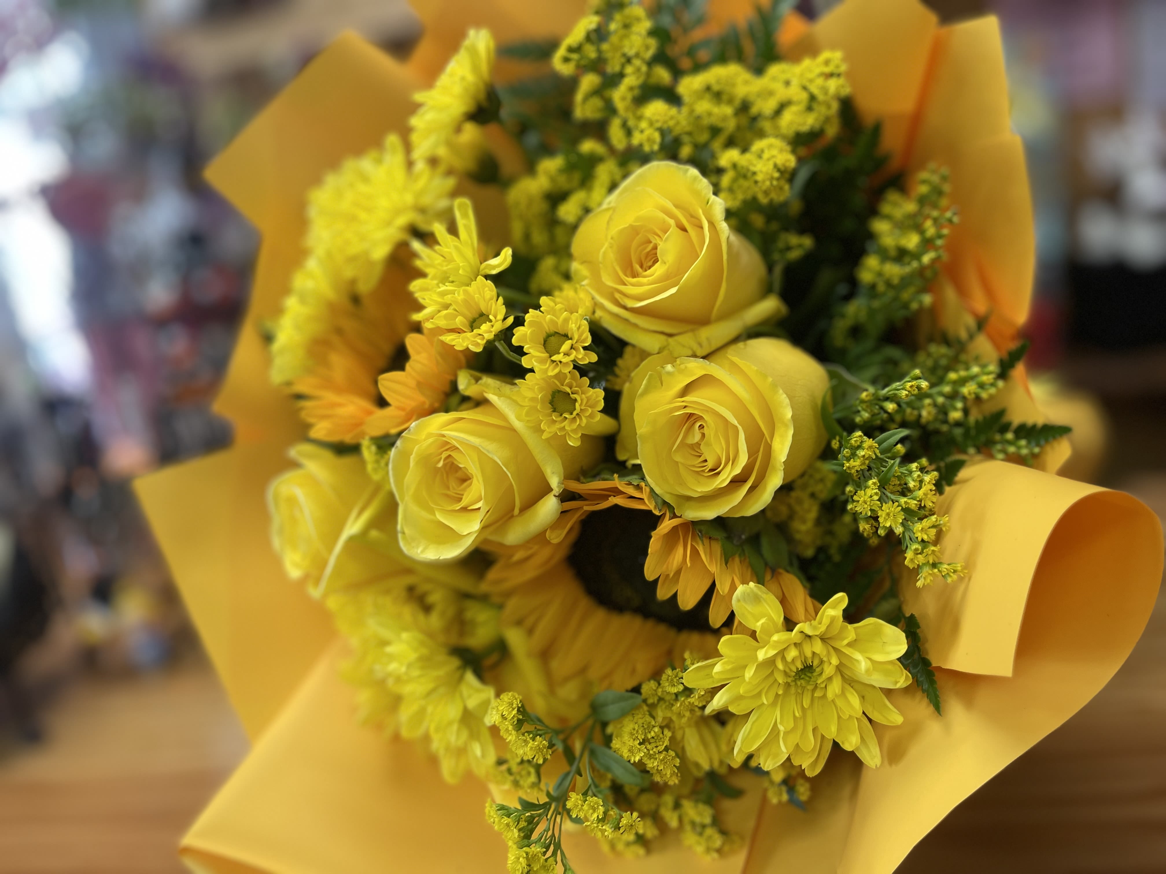 Yellow rose and chrysanthemum bouquet wrapped in yellow paper