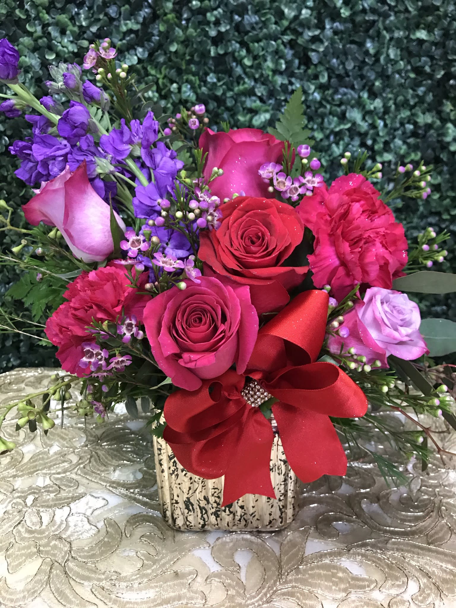 Pink and red rose bouquet with purple flowers in a square vase