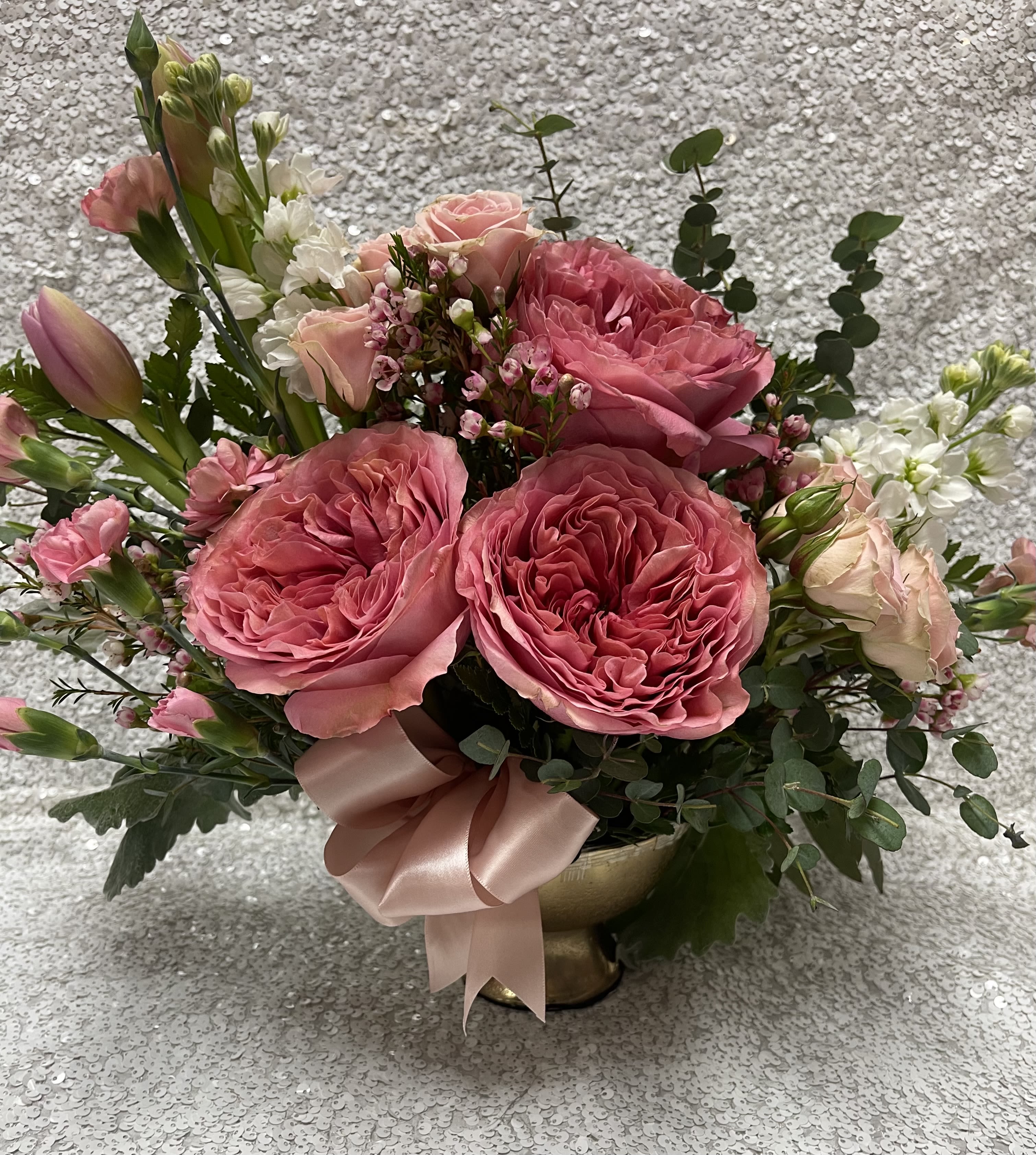 Pink rose bouquet in a gold vase with a satin ribbon