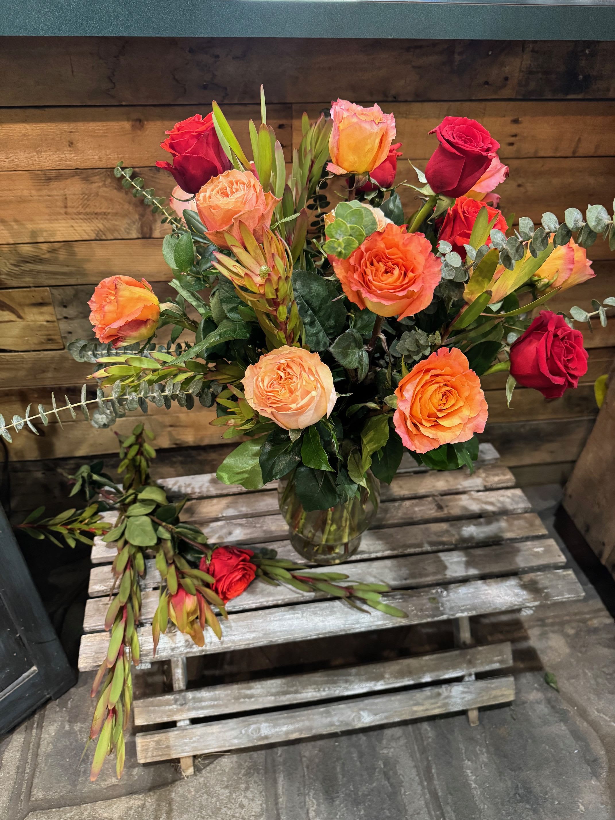 Mixed roses in a glass vase with eucalyptus